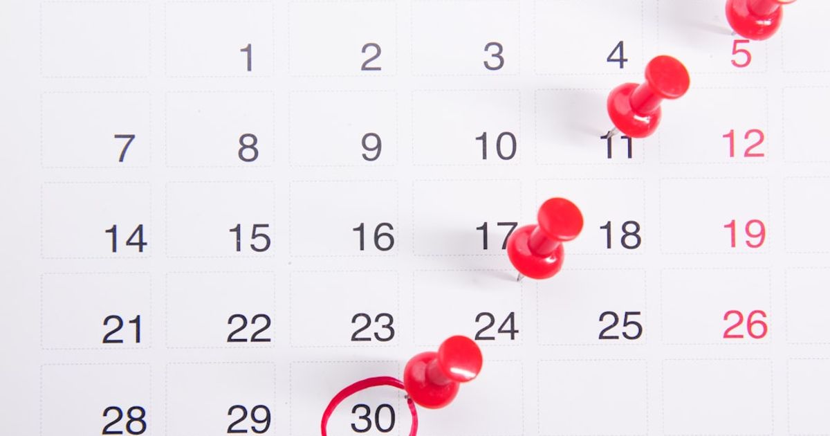a calendar with red push buttons pinned to it