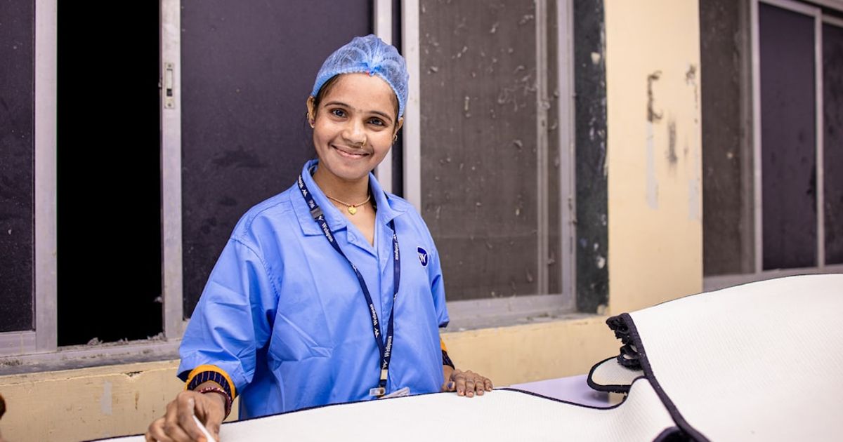 A smiling woman in surgical attire.