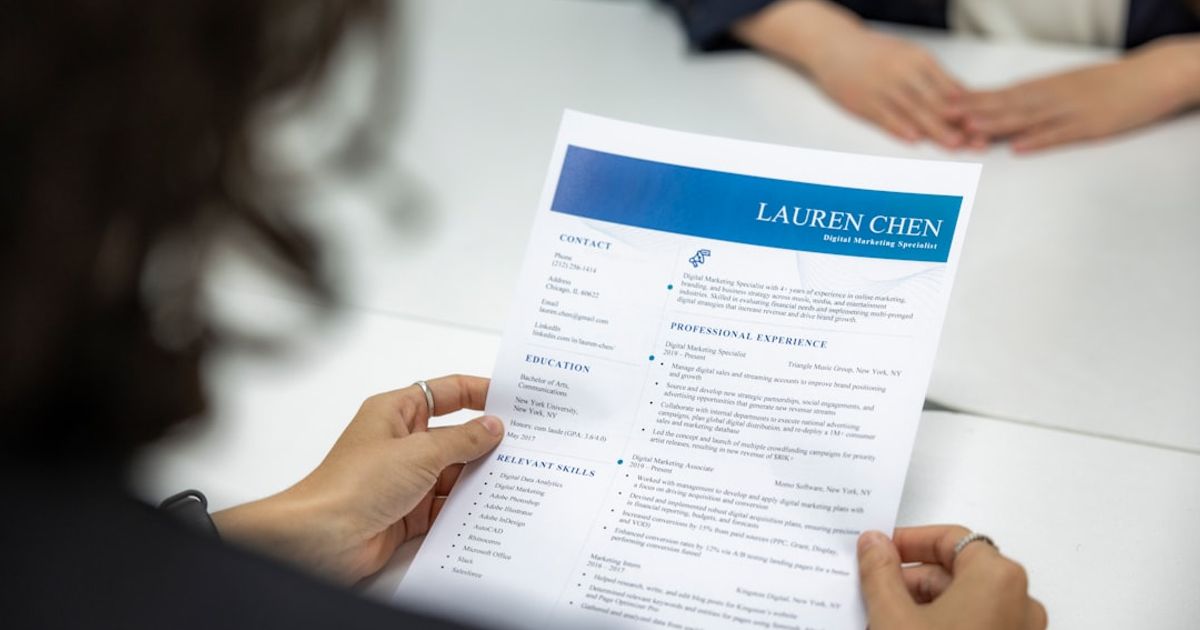 a woman is reading a resume at a table