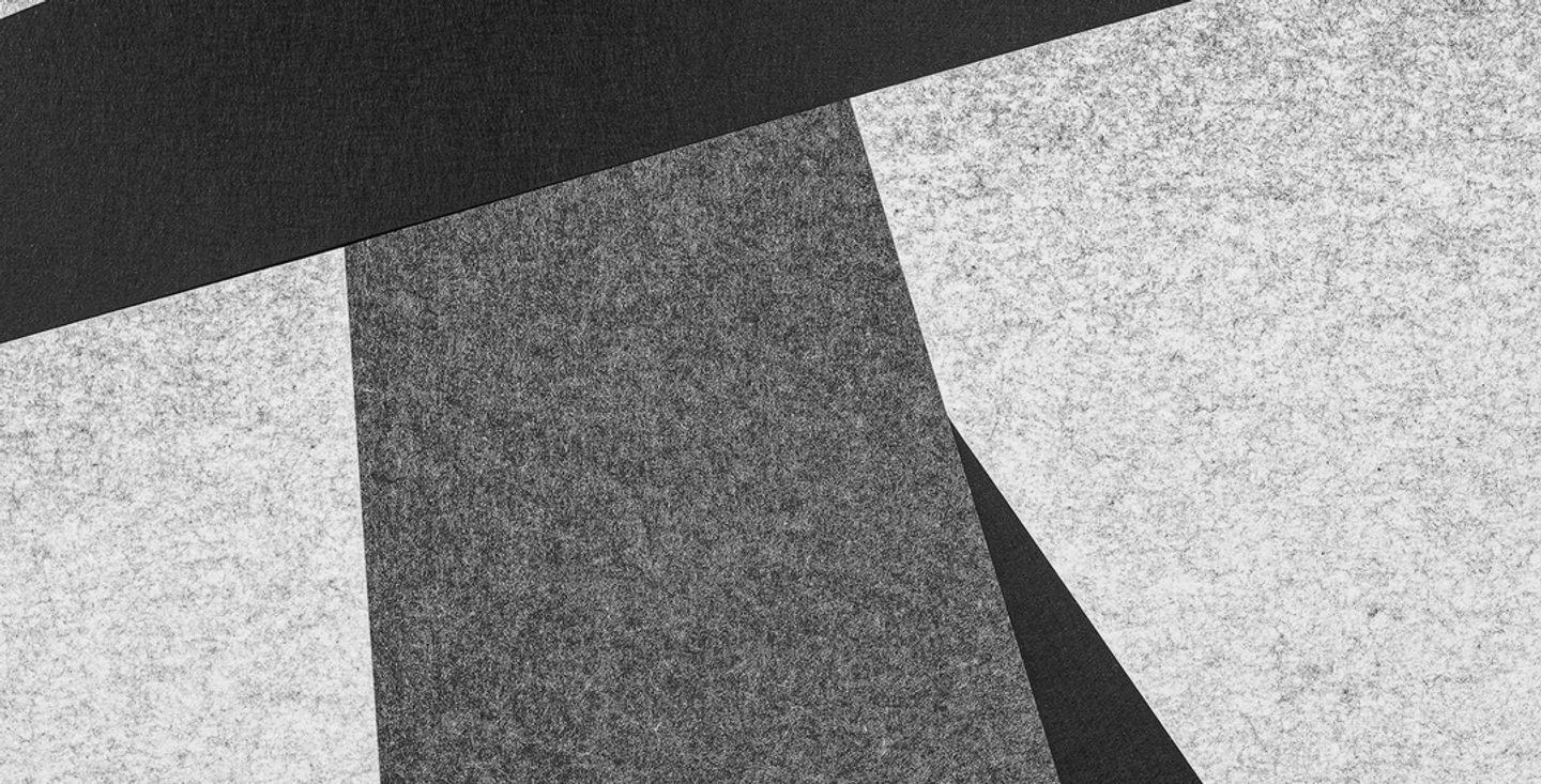 Ordered geometric planes of grey and texture, representing the structured business case for continuous employee feedback