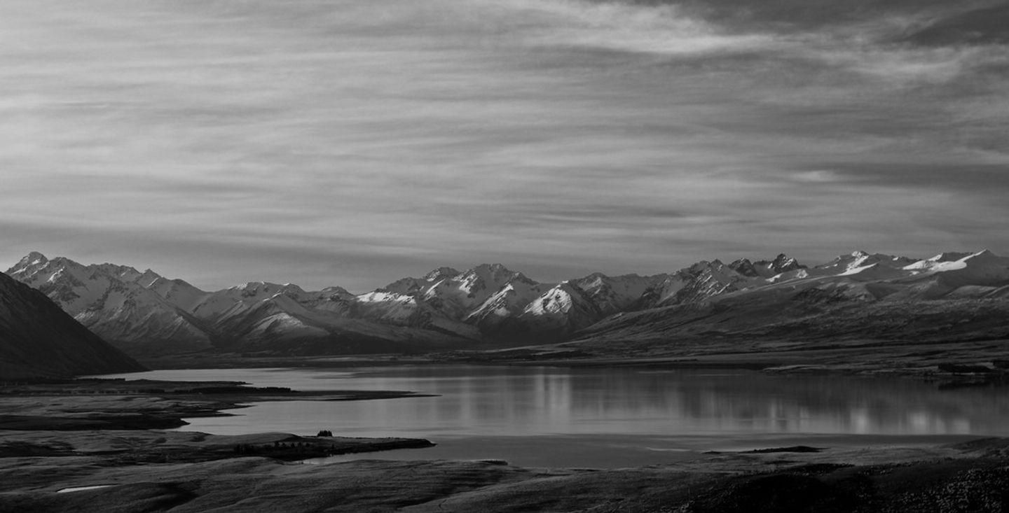 First light over a still lake and mountain landscape, representing a second act for pulse survey tools