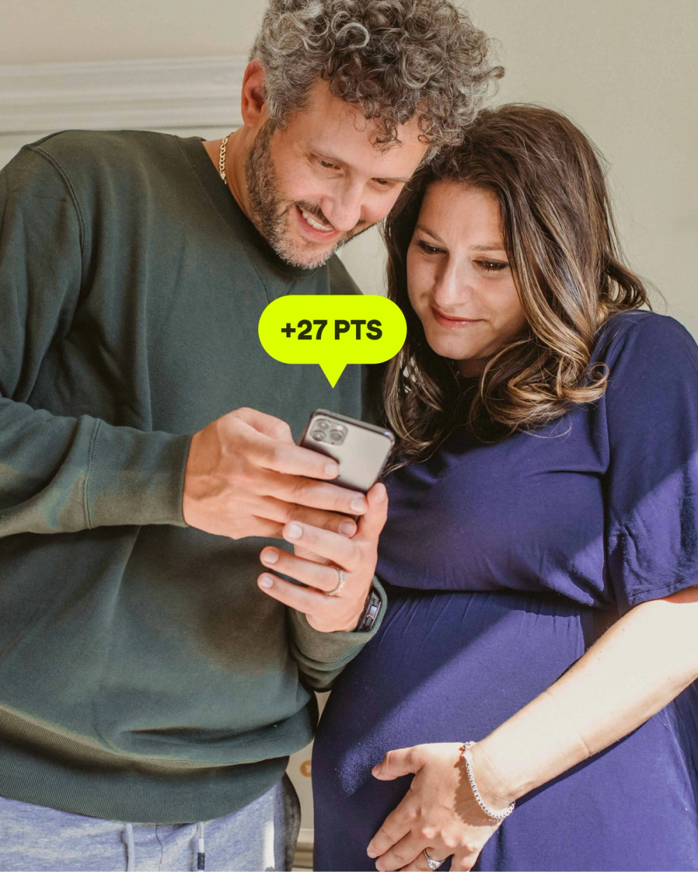 Millennial couple expecting a child looking at the man's credit scores in the KOHO app