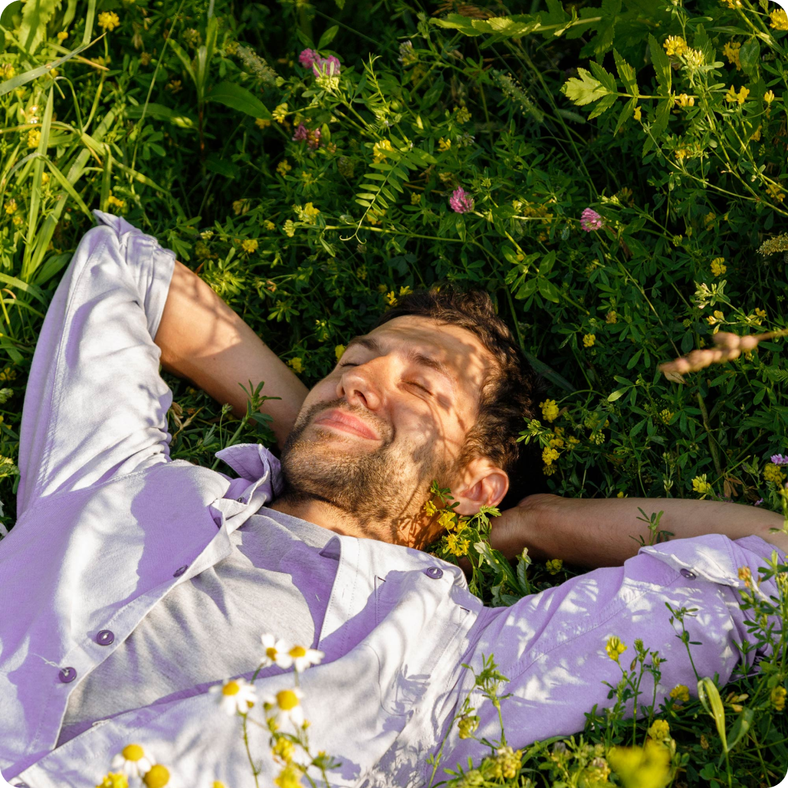 Un homme se détend sur l'herbe en sachant qu'il est protégé par l'assurance locataire.