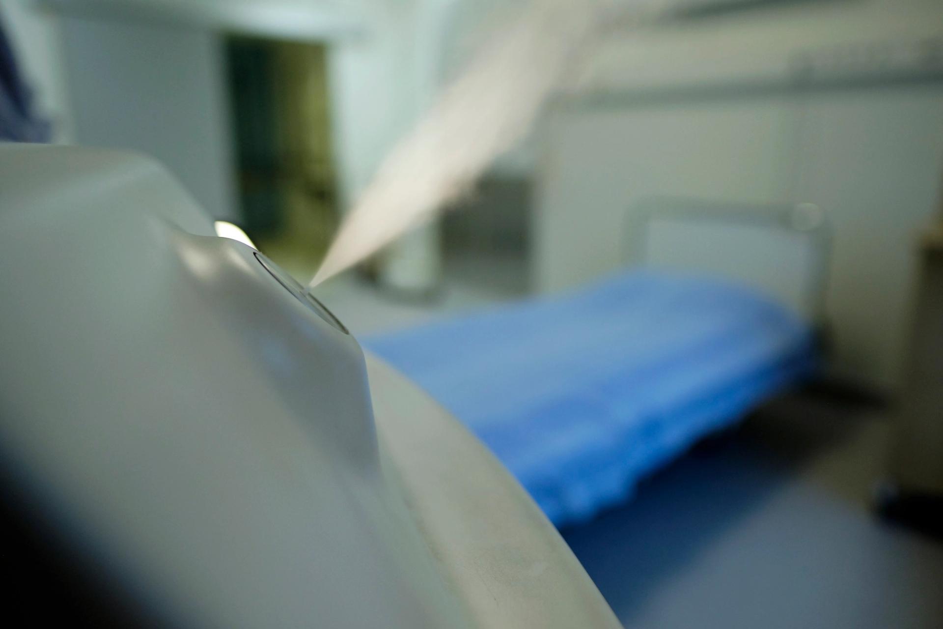 Dry disinfecting mist coming out of a nozzle in a hospital room
