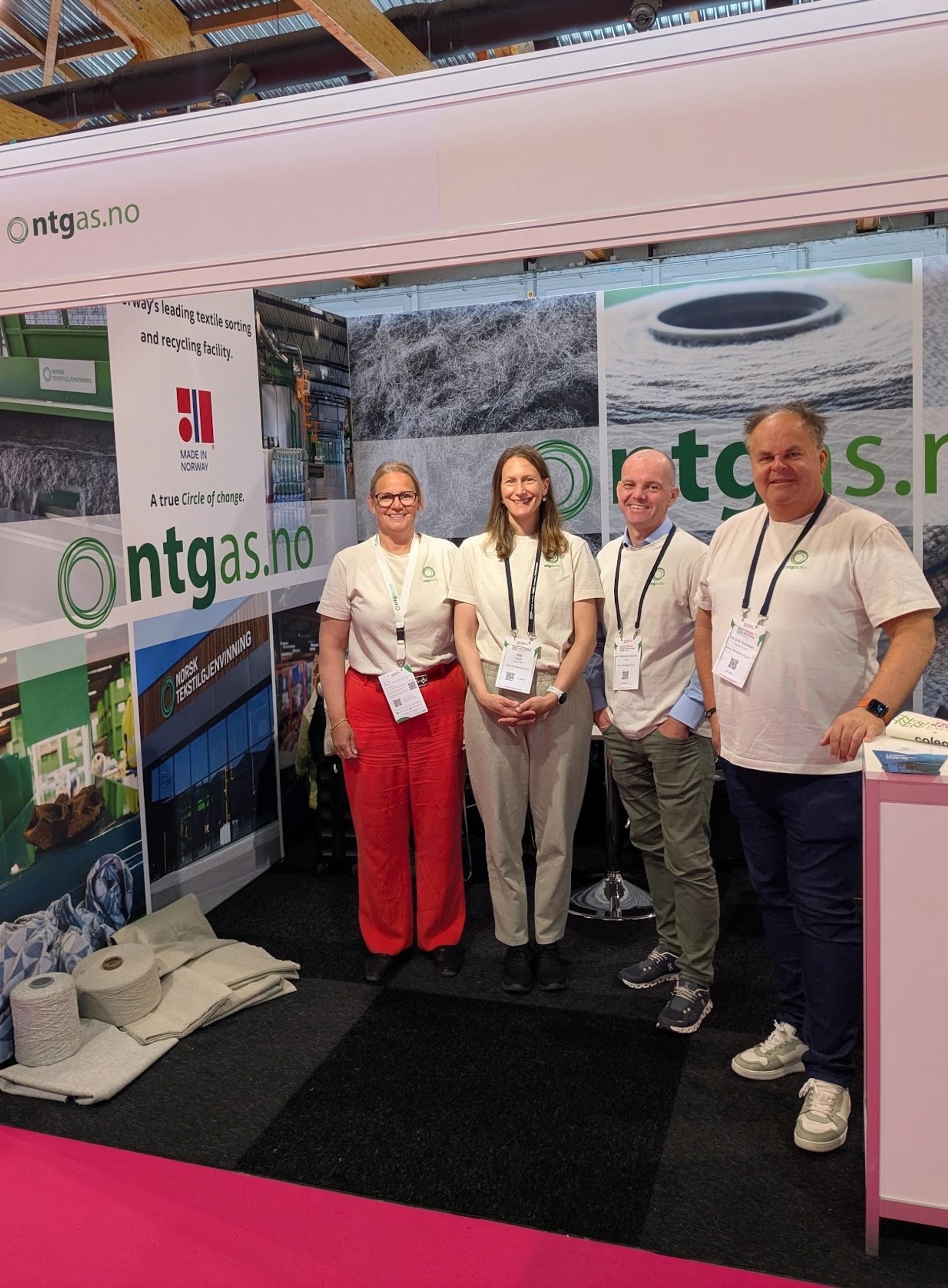 Employees of NTG on smiling to the camera, while working on their stand.