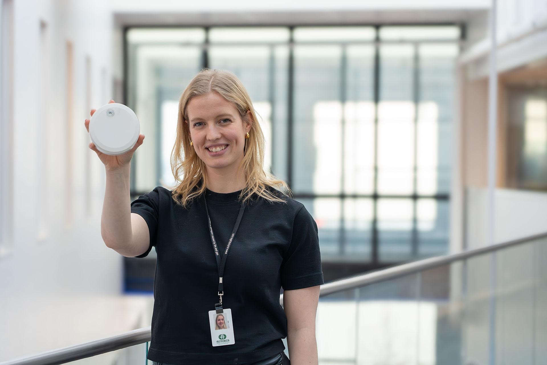 Girl with black t-shirt holding a fire safety products from Autronica