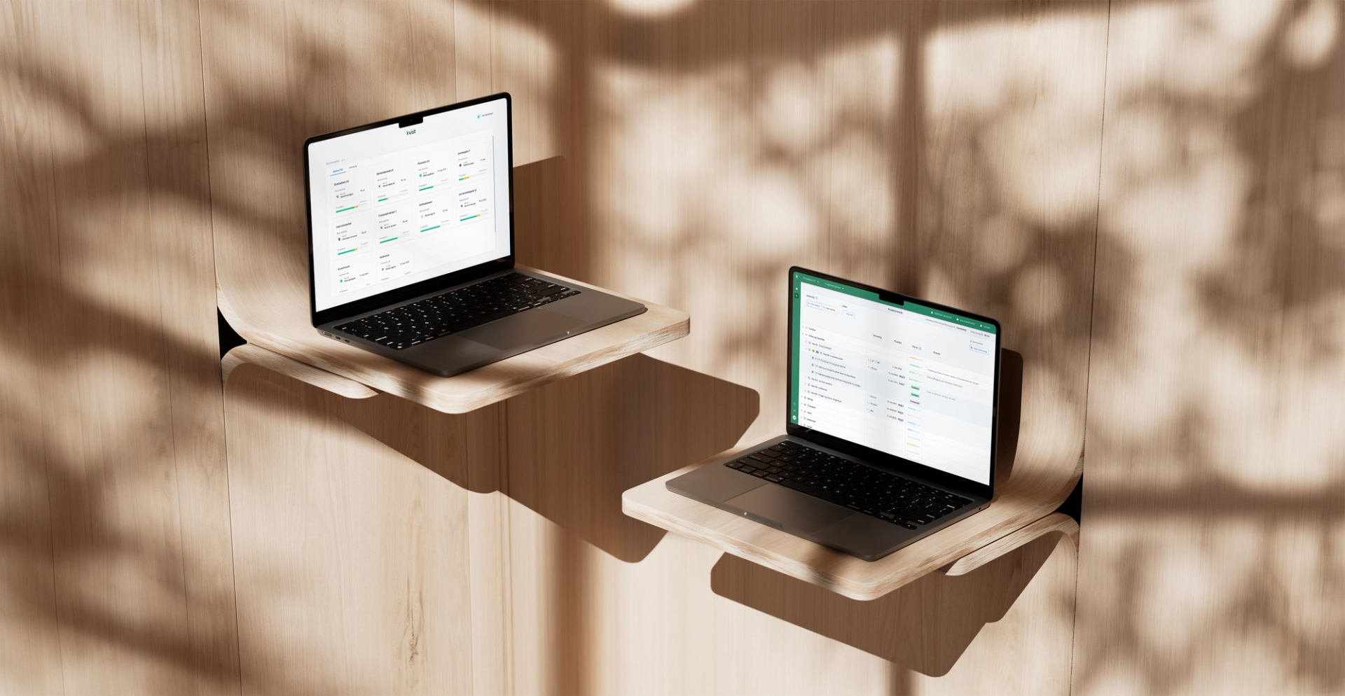 Two open laptops on a wooden shelf against wooden panelling