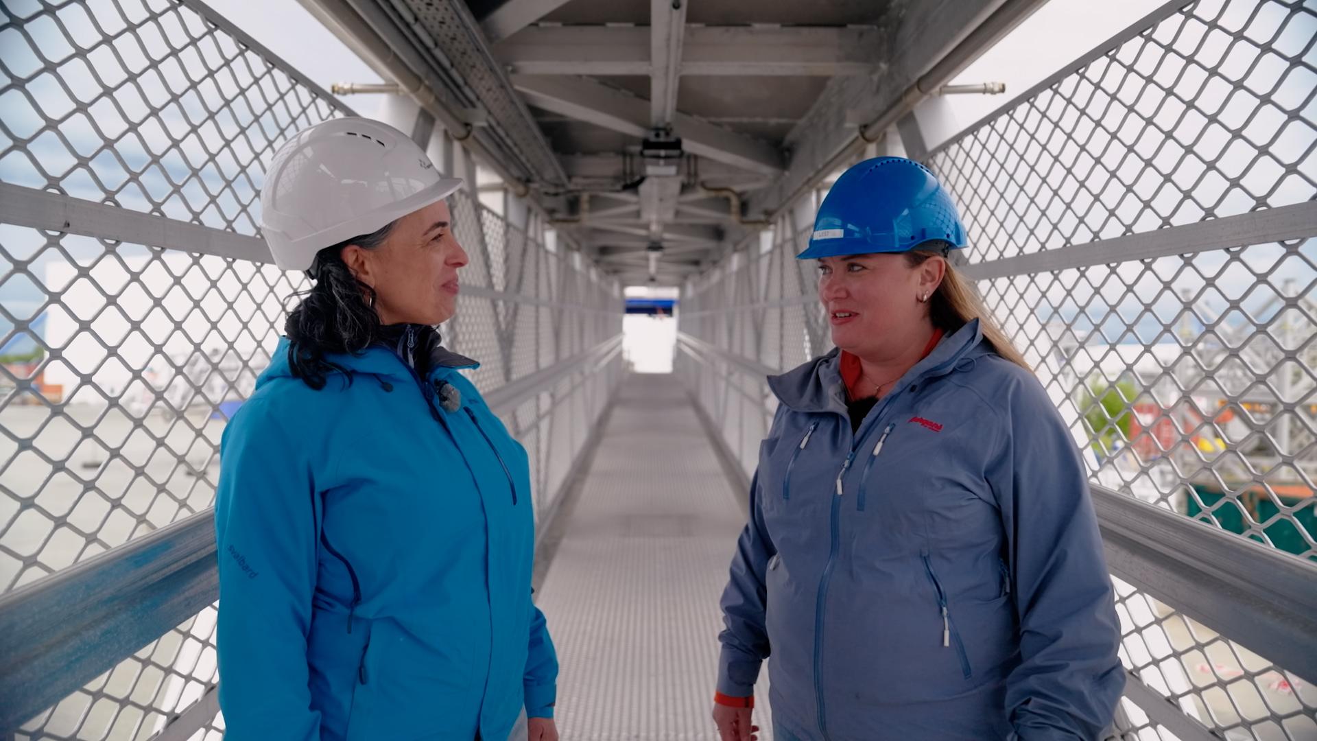 Two women in hard hats standing on an autonomous gangway