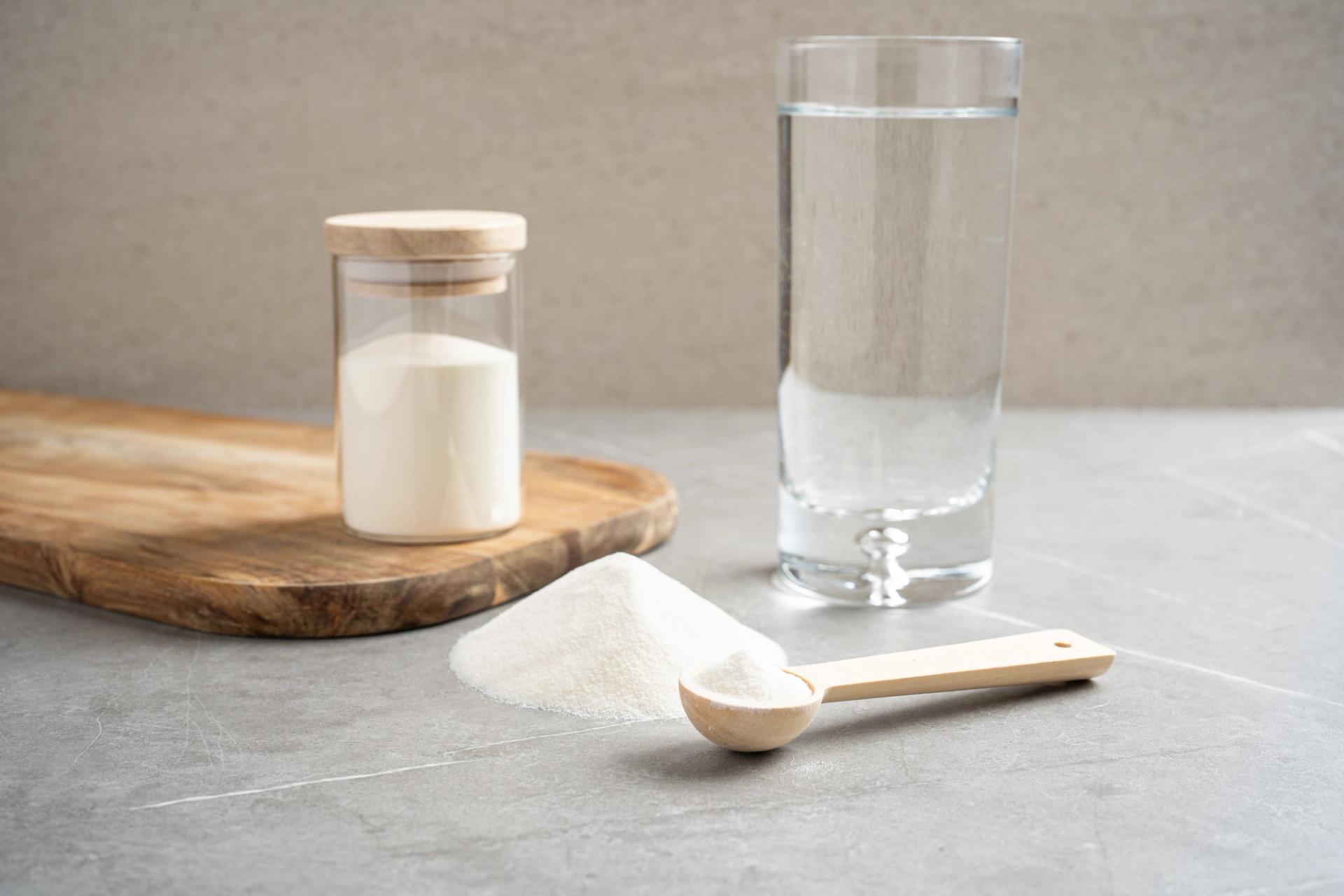 white powdered salmon collagen next to a glass of water