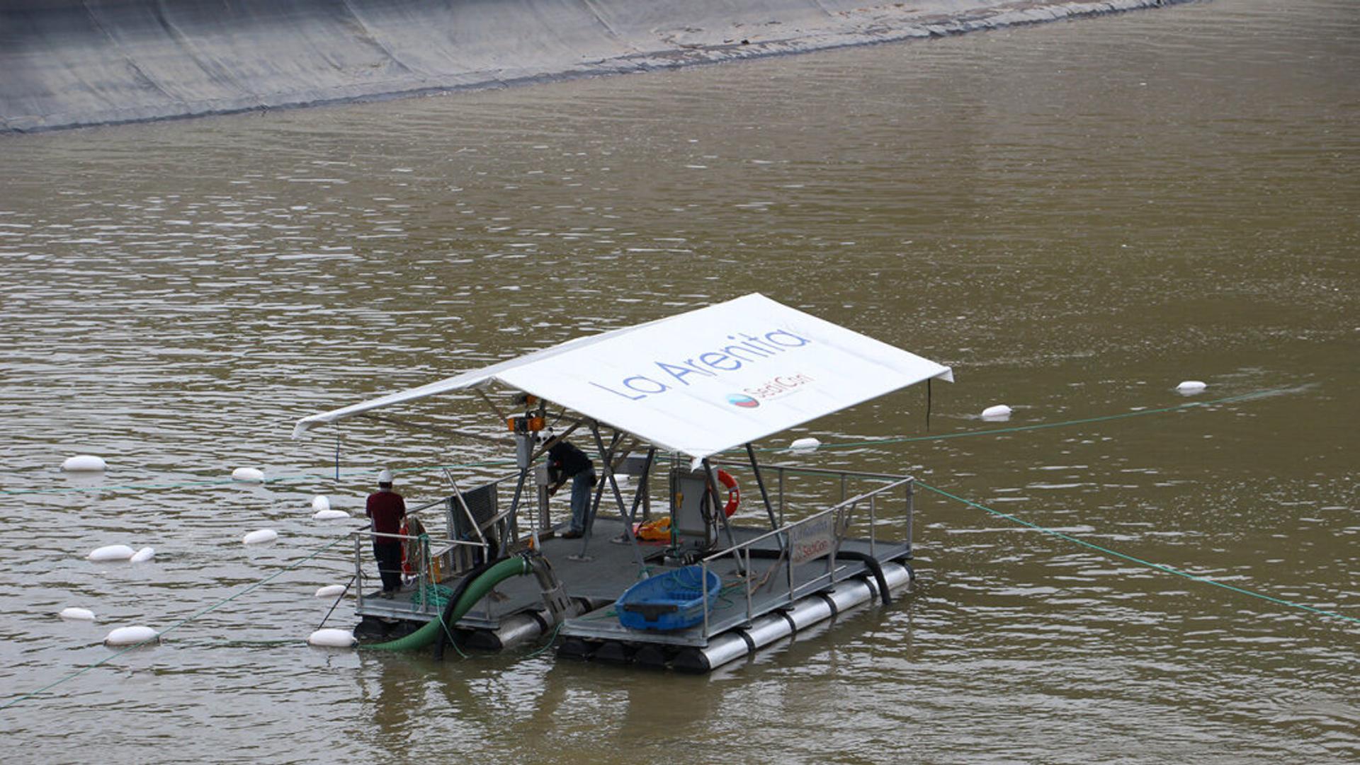 People using gravity-powered hydrosuction system for removing sediment from reservoirs