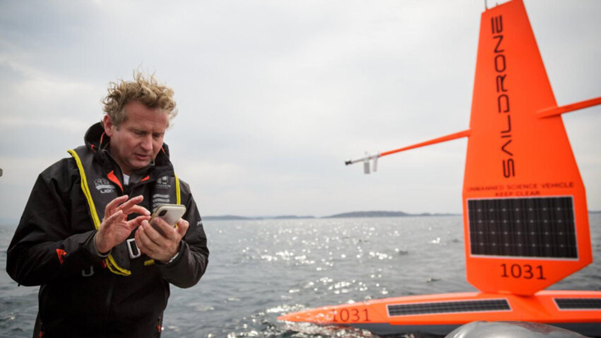 Man using phone beside drone