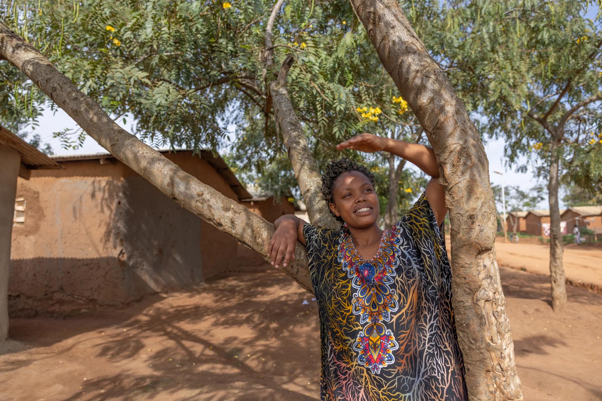 Woman in colourfull dress shading for the sun in a dry landscape