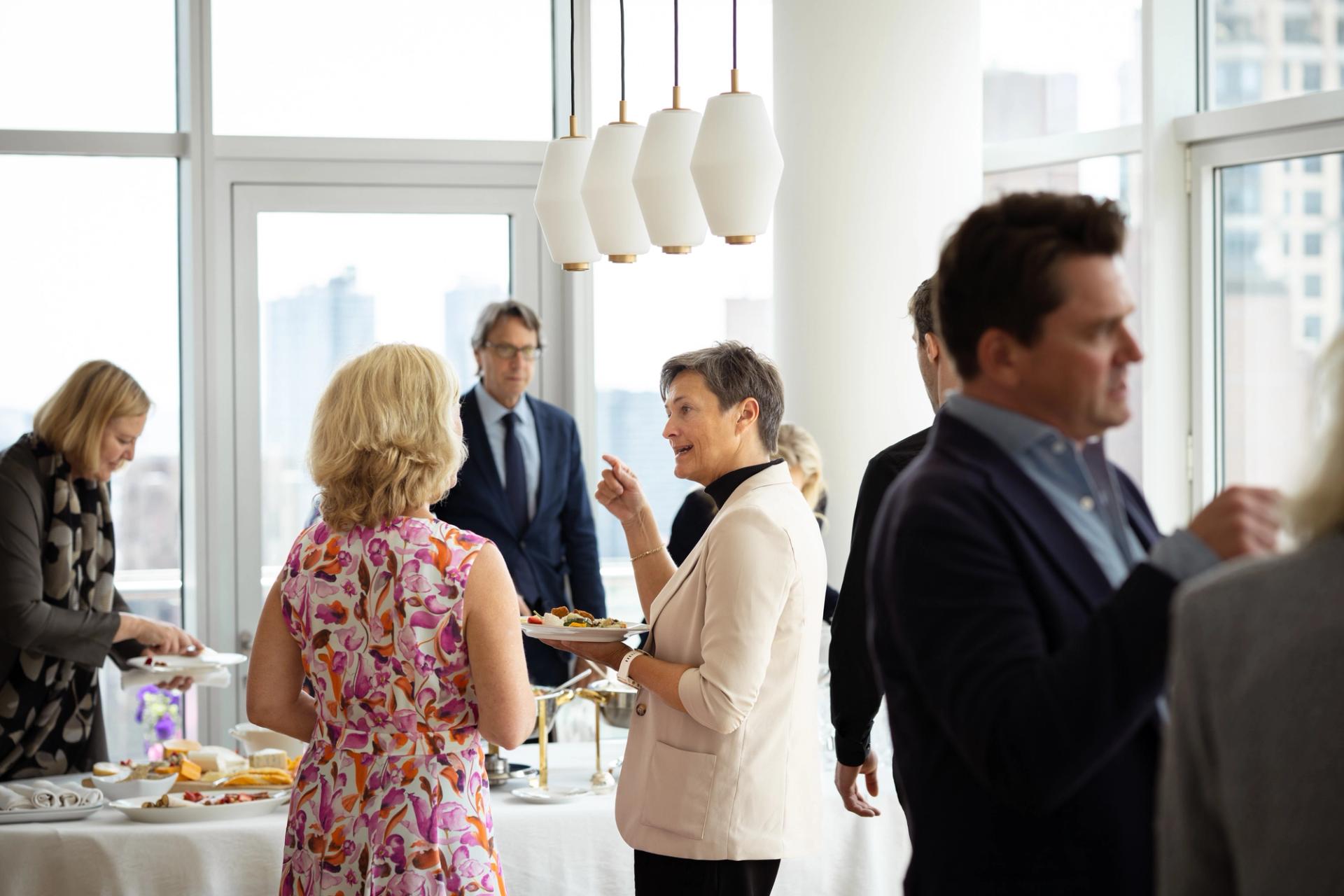 People mingling at a party some holding food and a drink