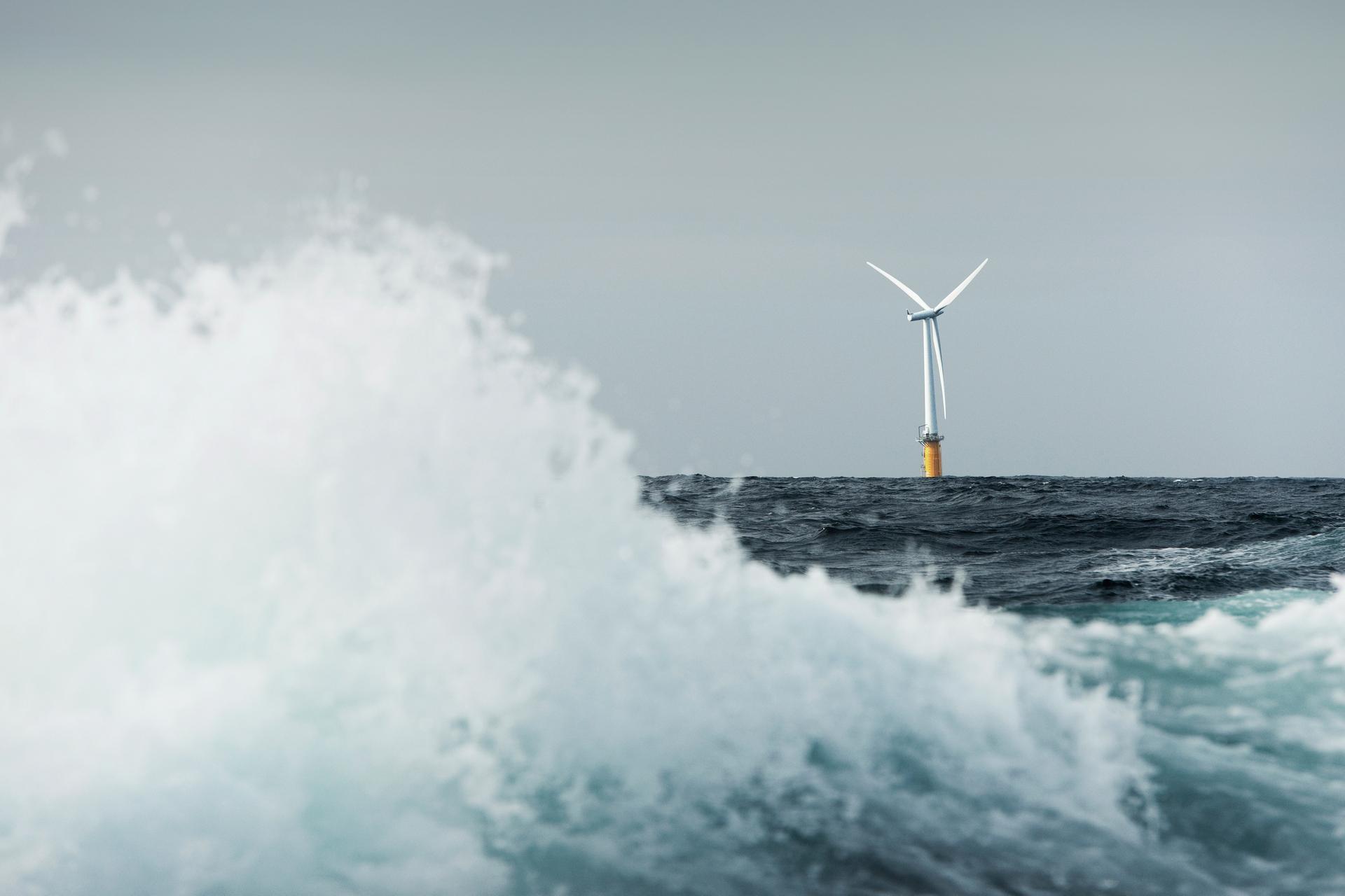 Floating offshore wind turbine on the horizon with large wave in the foreground