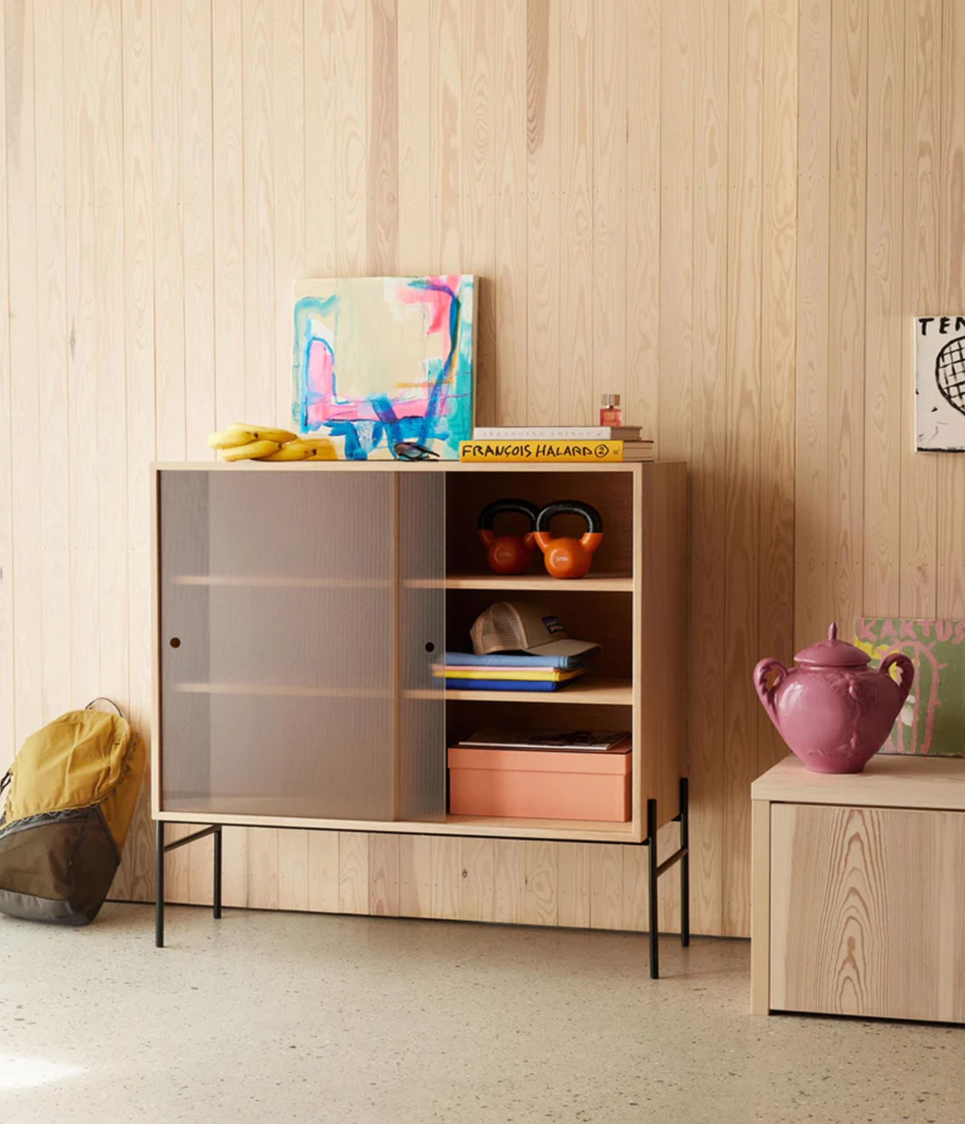 cabinet in light wood on thin black metal legs with frosted glass doors