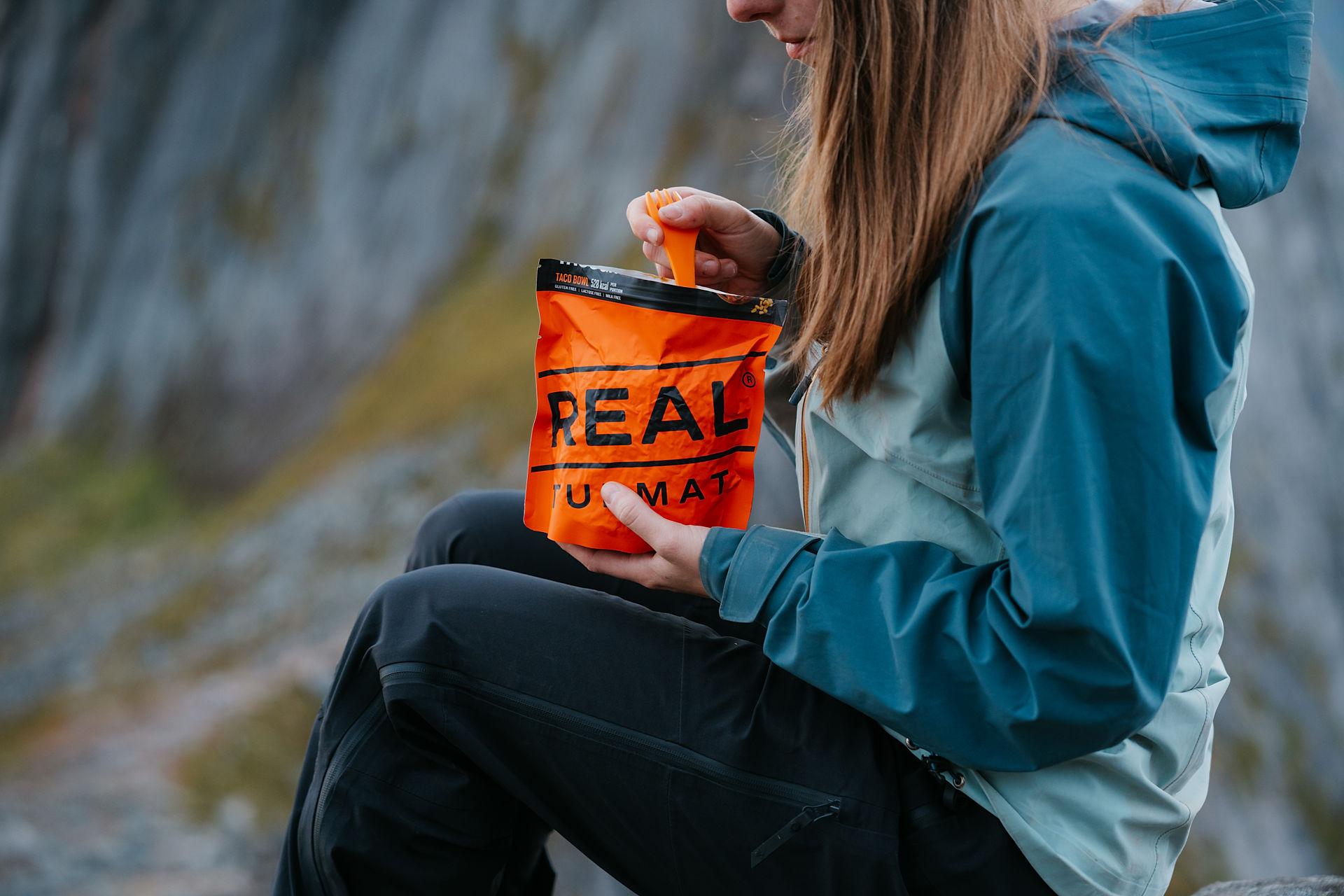 Woman eating Real turmat in the mountains.