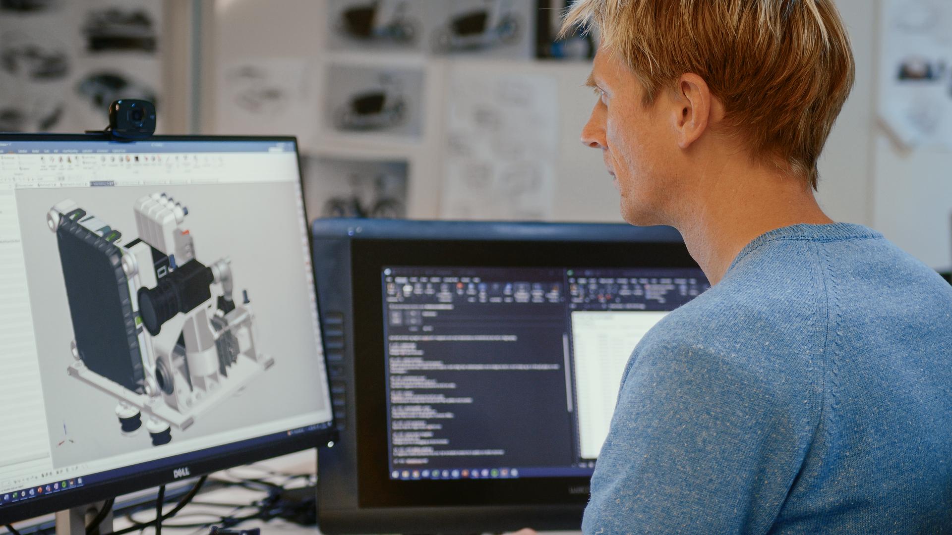 Man in front of two computer screens