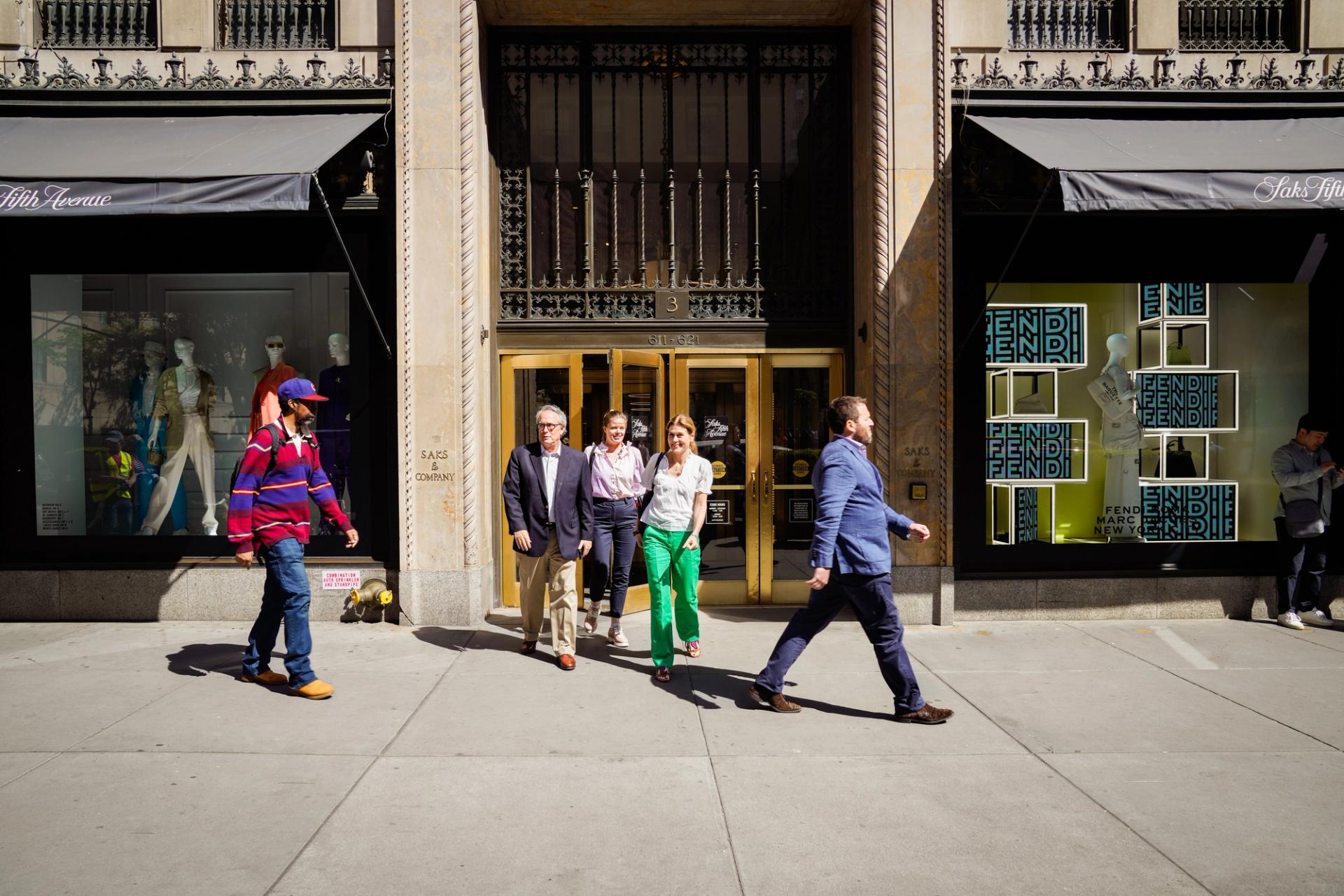 Three people exiting Saks Fifth Avenue in New York City