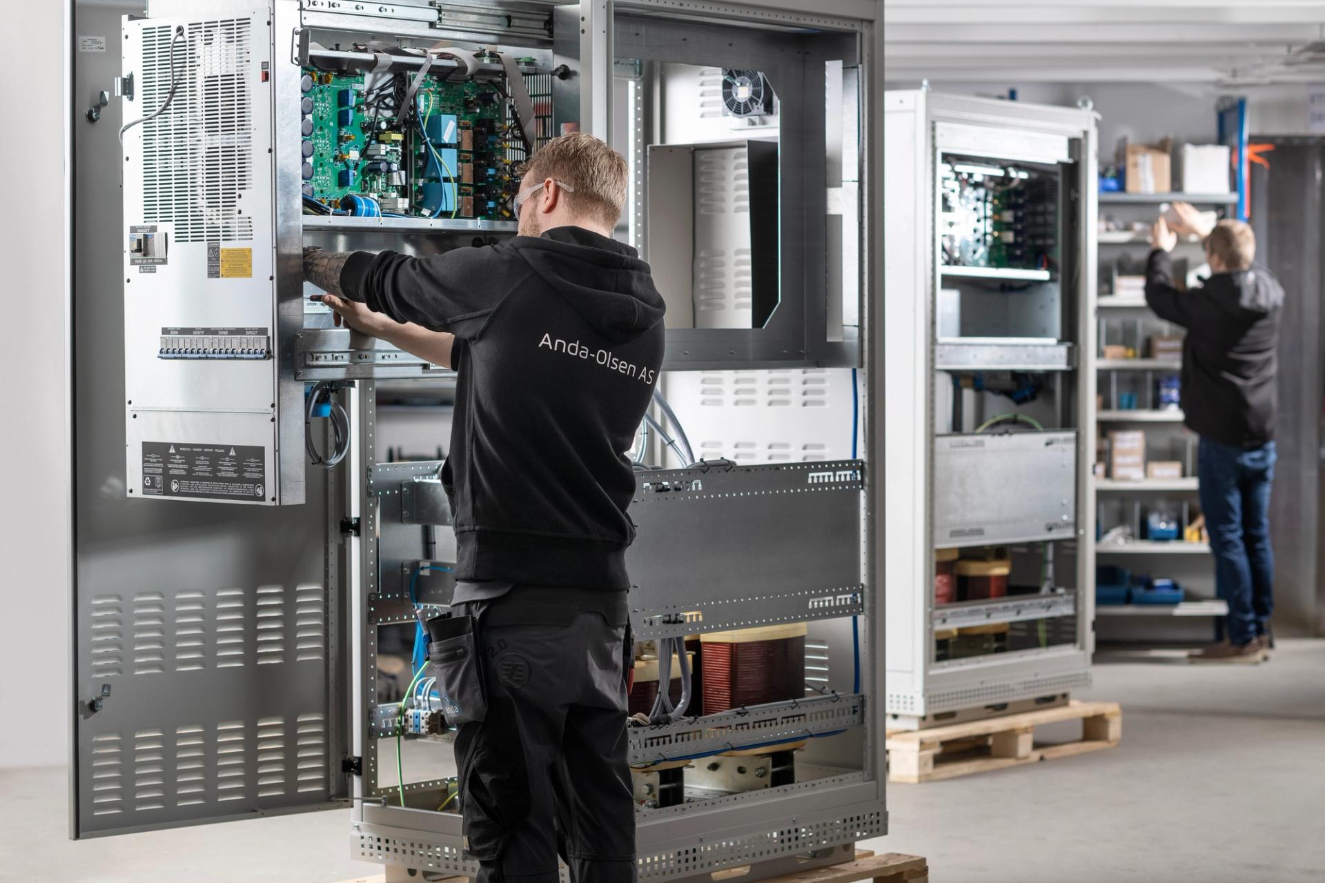 Repairmen in front of containerized power supply systems
