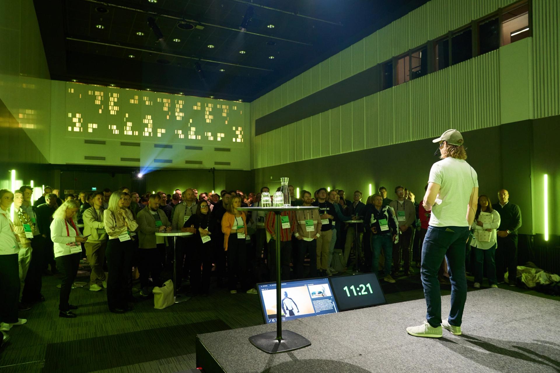 Man speaking on stage in front of crowd