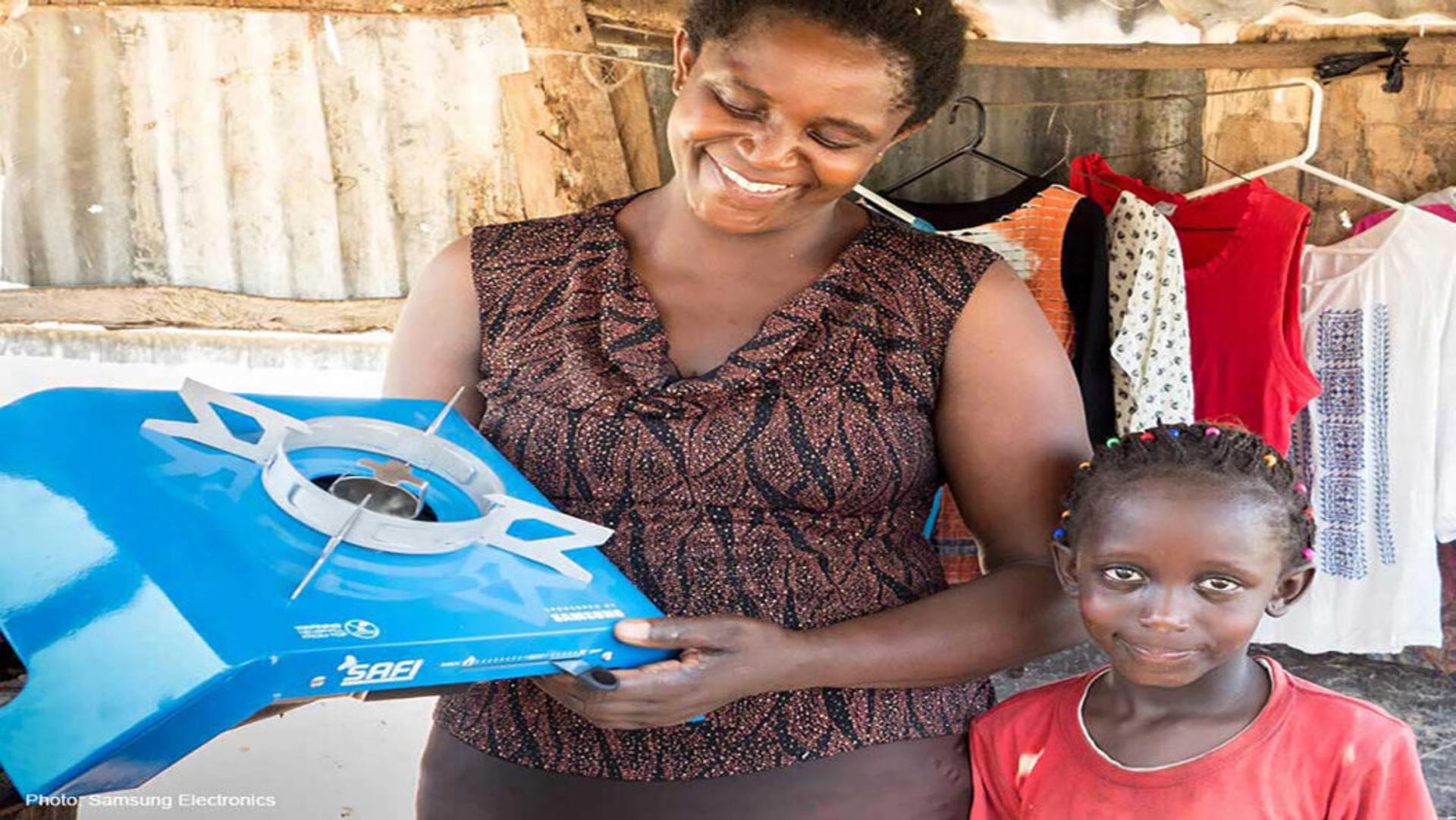 Woman next to a child holding a blue single burner bioethanol stove