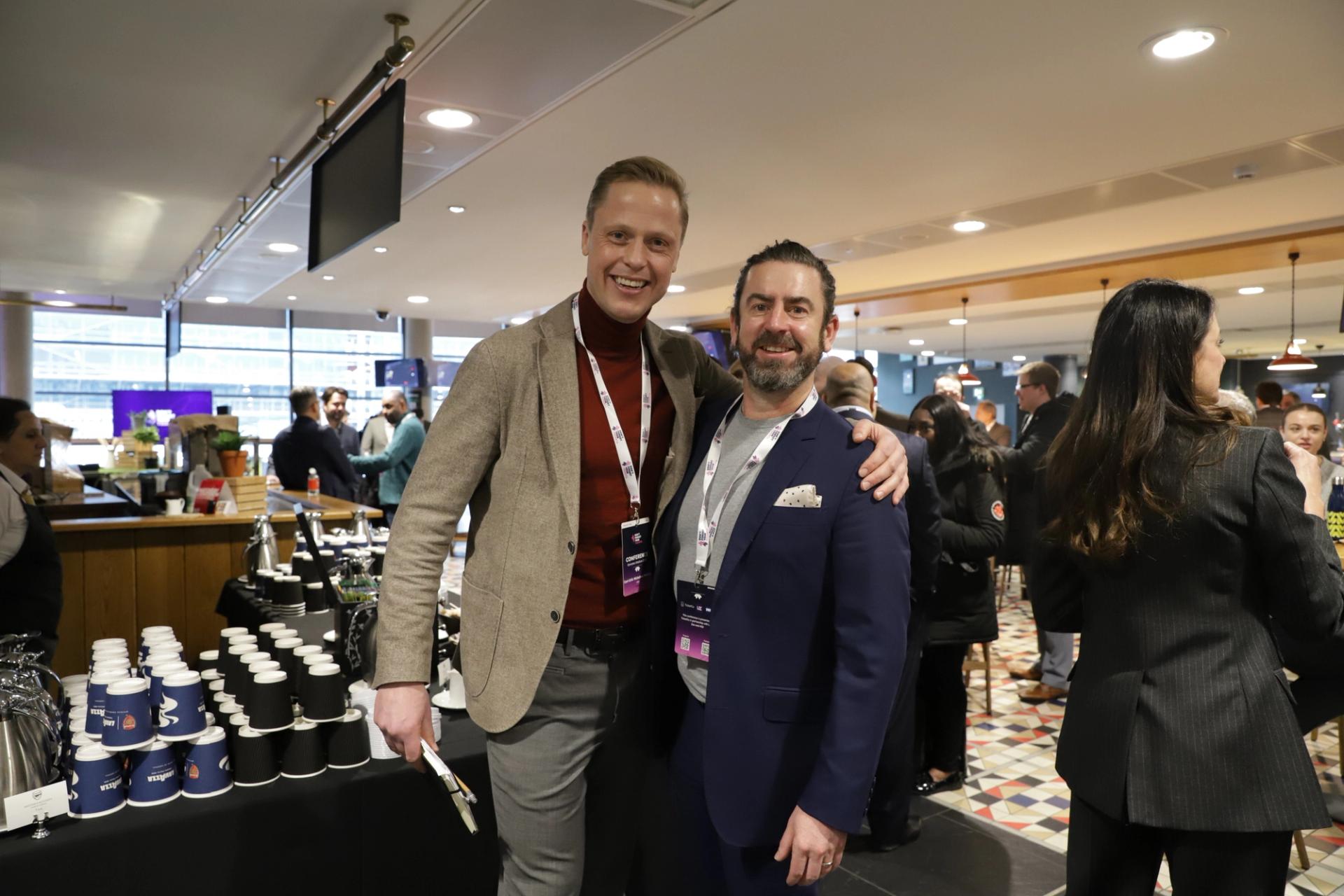 Two men in suit smiling at the camera