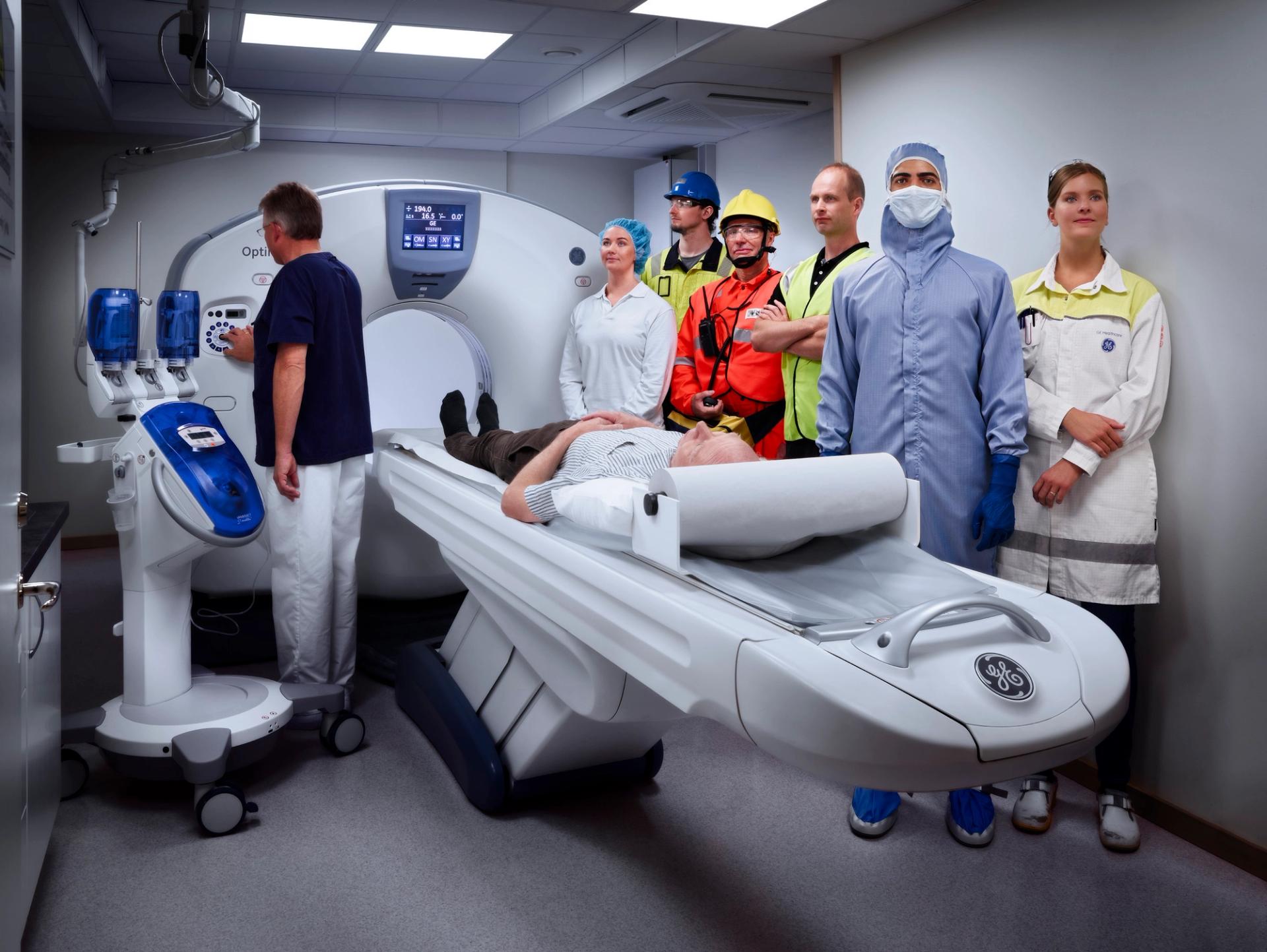 Health care personnel lined up aside a CT scanner