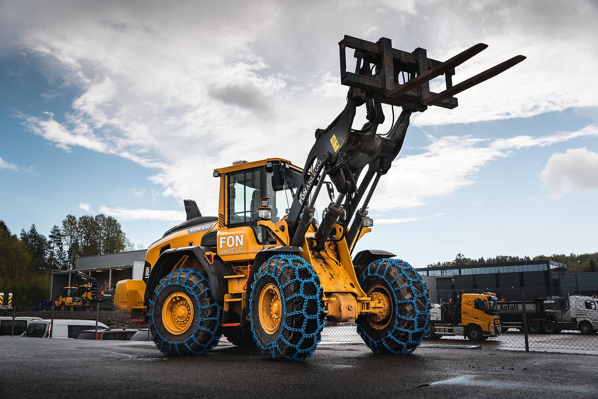 A yellow forklift with blue chains on the tires.