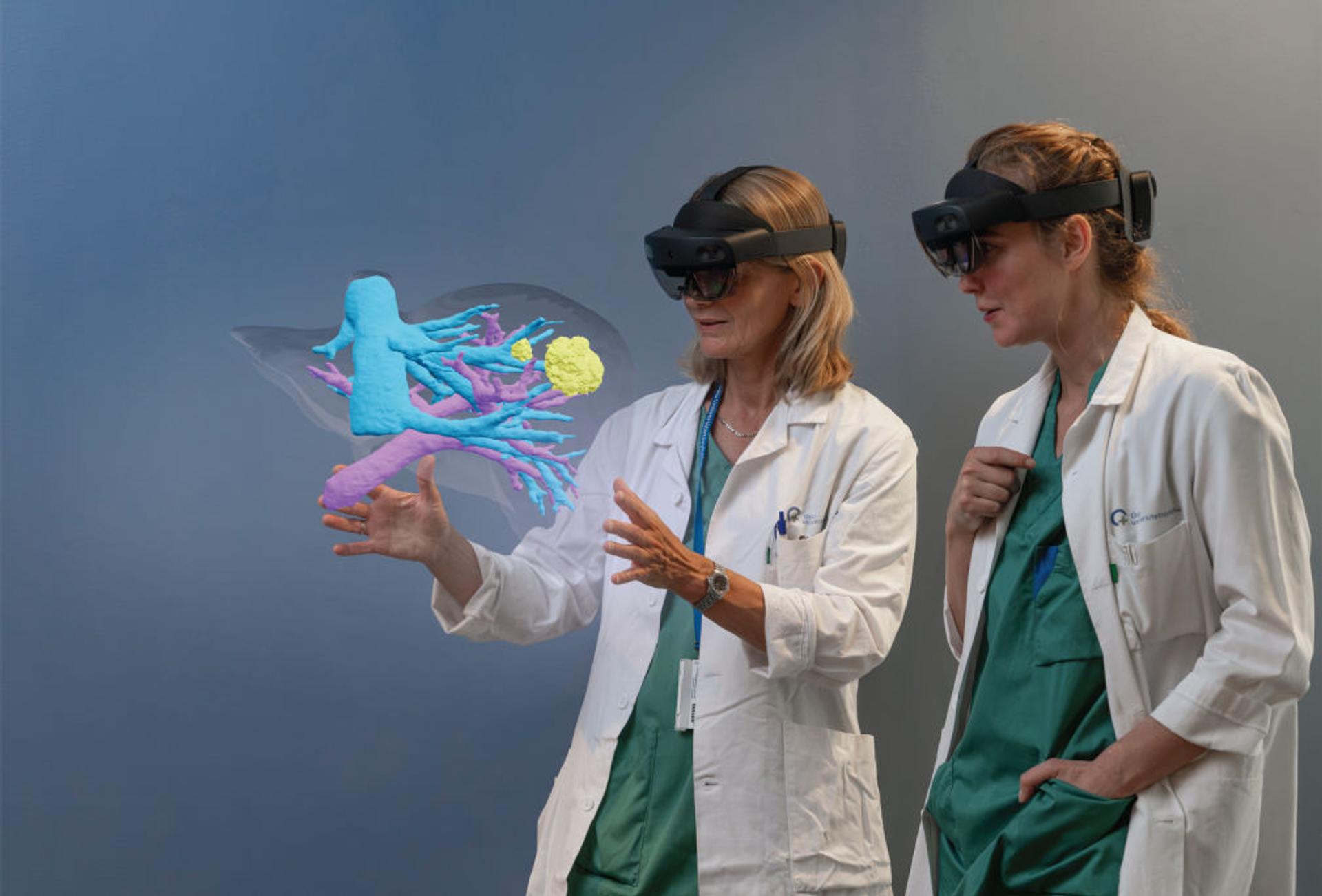 Two female hospital workers looking at a 3D hologram.