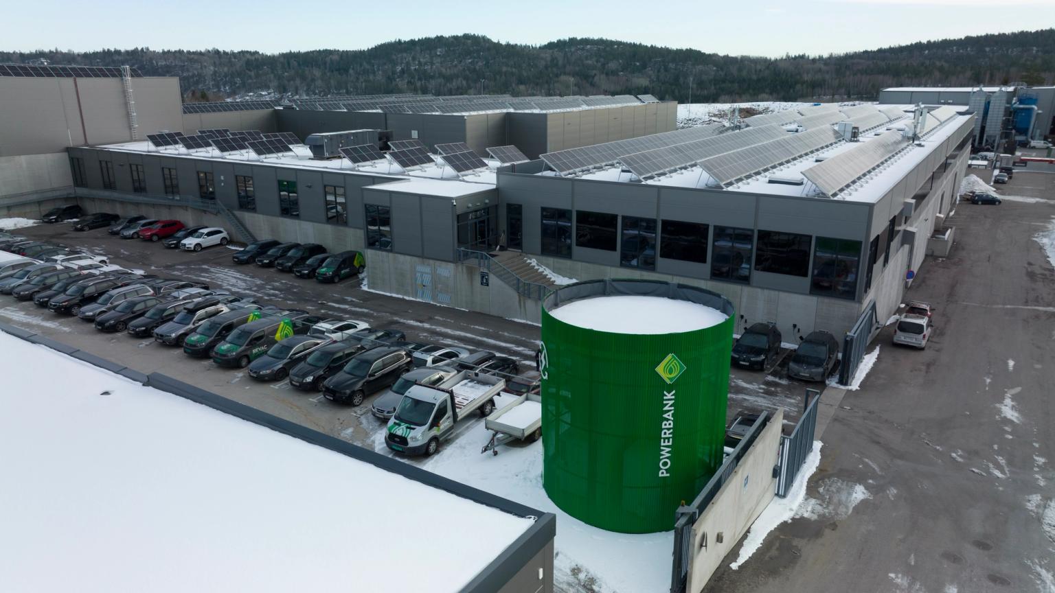 Grey production plant with a green cylindrical powerbank