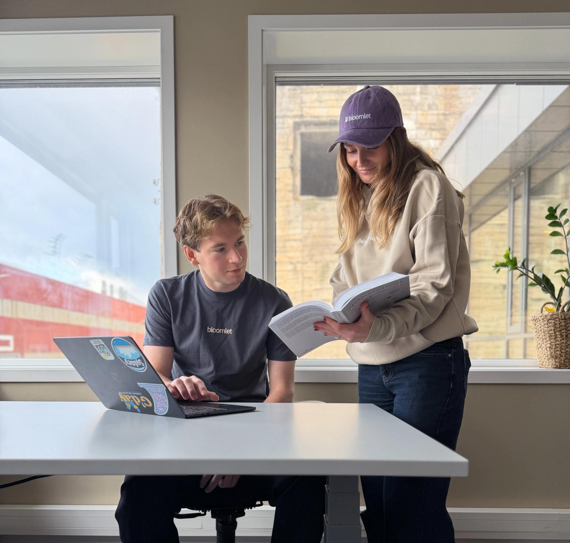 Girl showing a boy something in a textbook