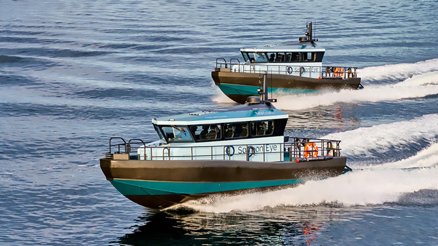 Two green electric workboats in the water