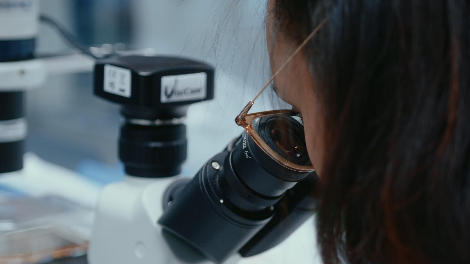 Woman looking into a microscope