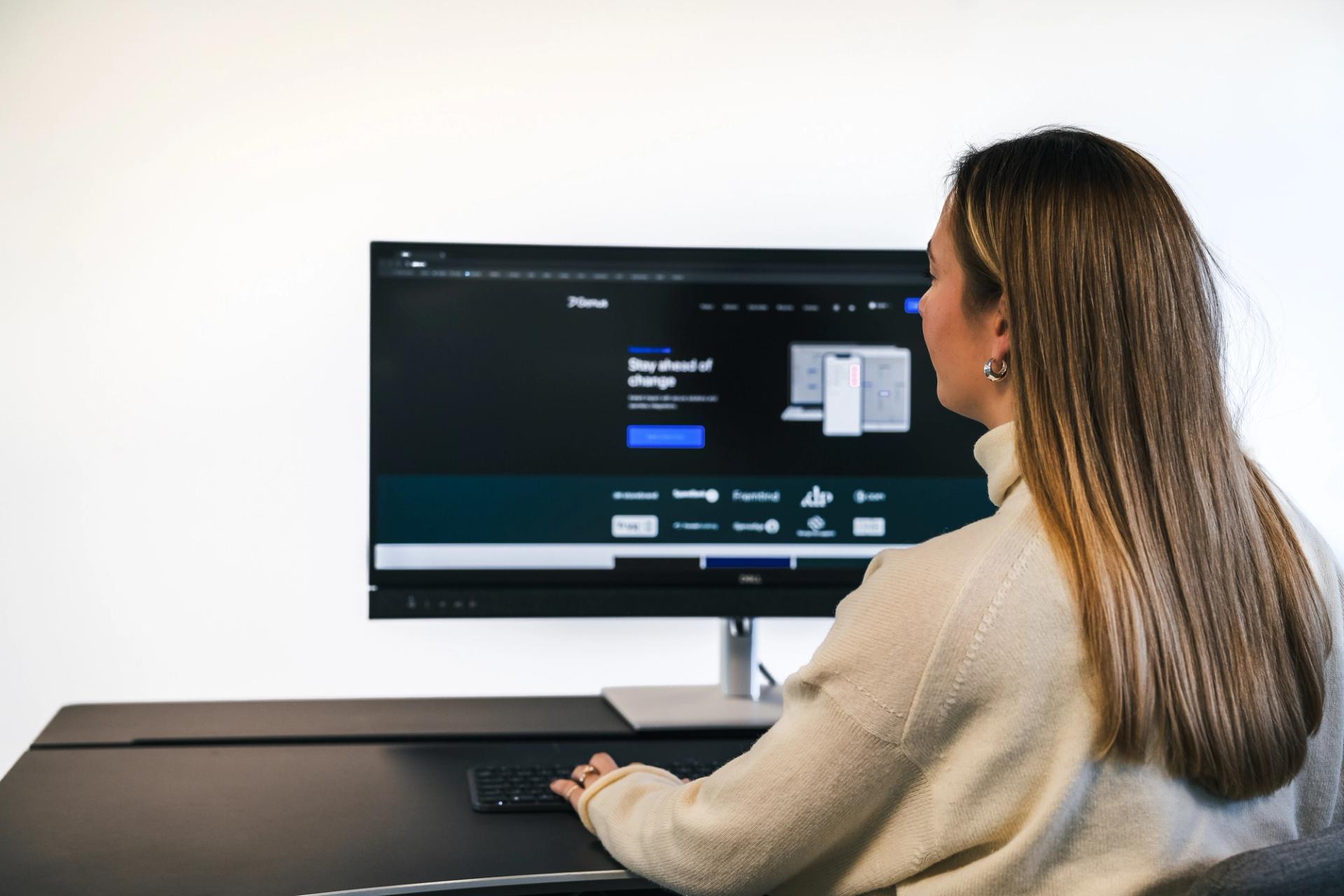woman at a desk looking at a screen
