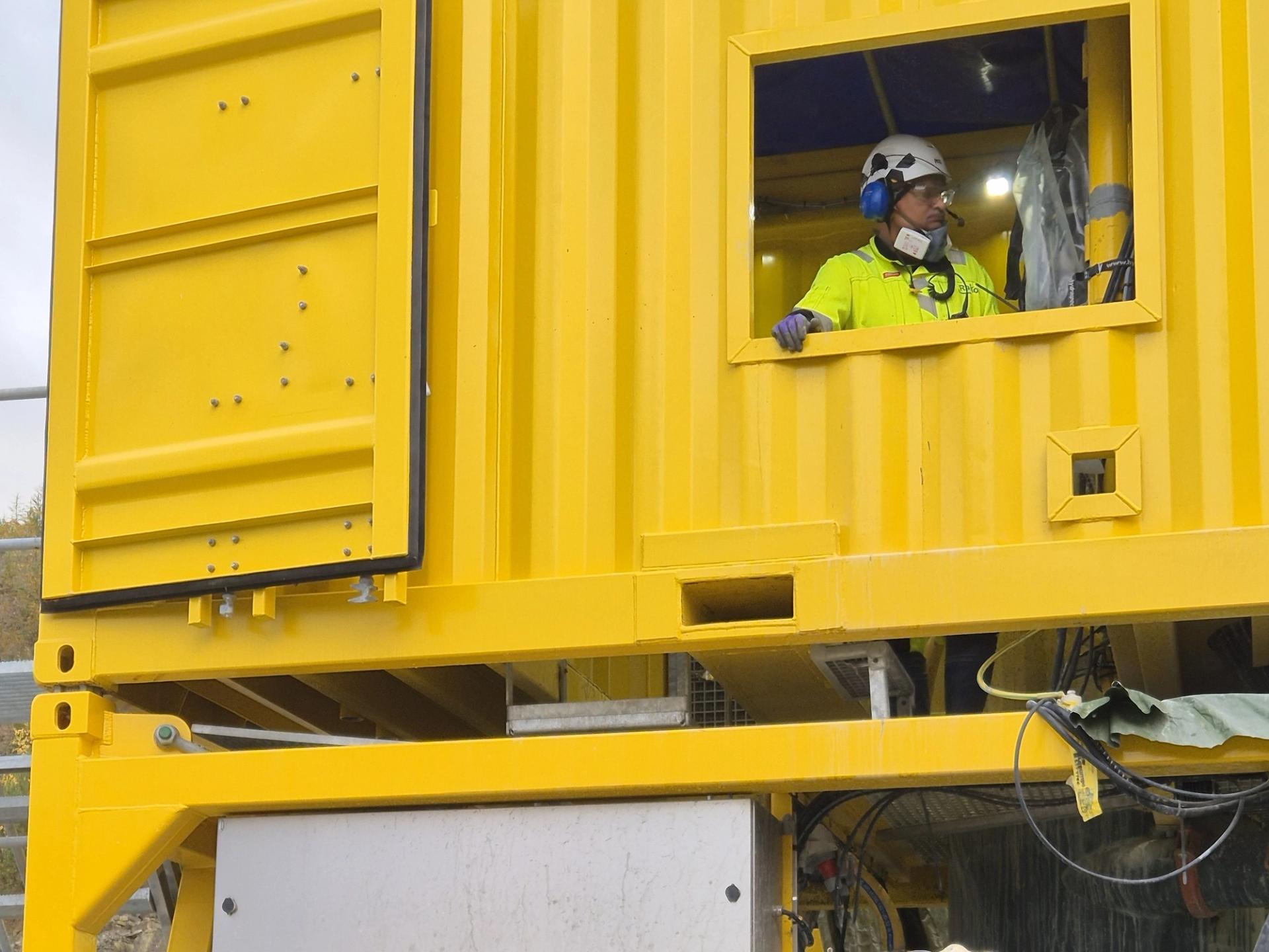 Worker in a rig performing grouting of offshore wind turbine foundation