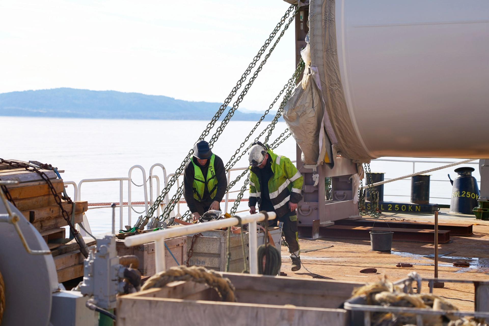 two workers on a boat building a floating offshore wind turbine