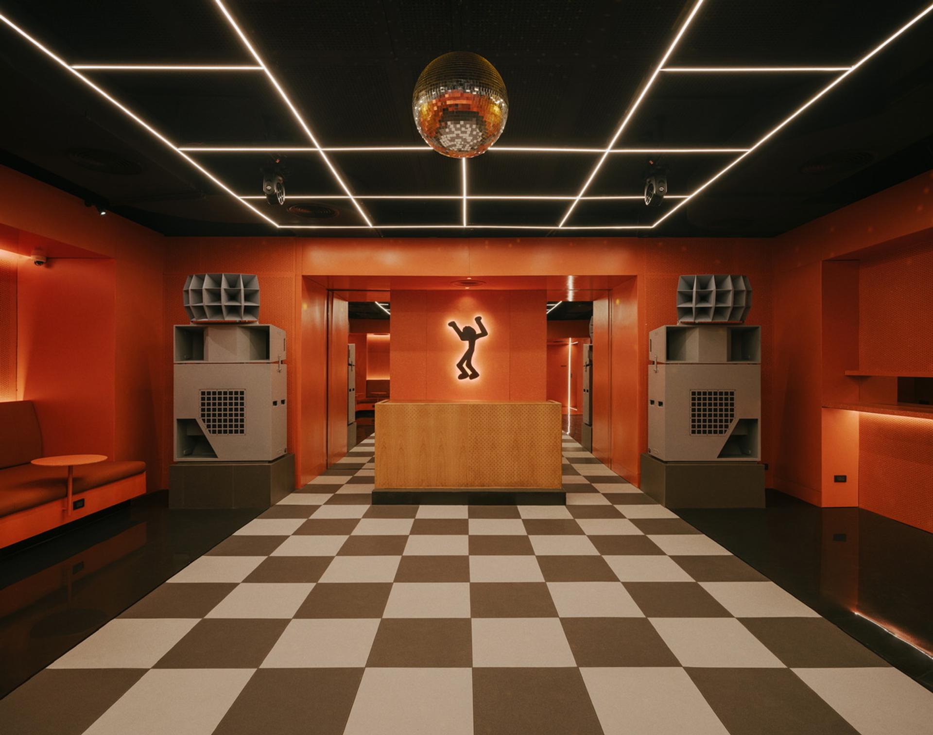 Loudspeakers in an orange club with a checkered floor