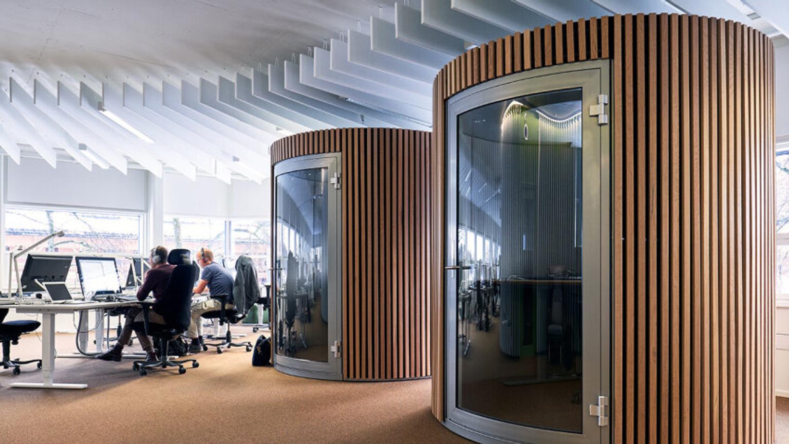 Two single-person meetingrooms inside an office. Wooden panels on the boxes