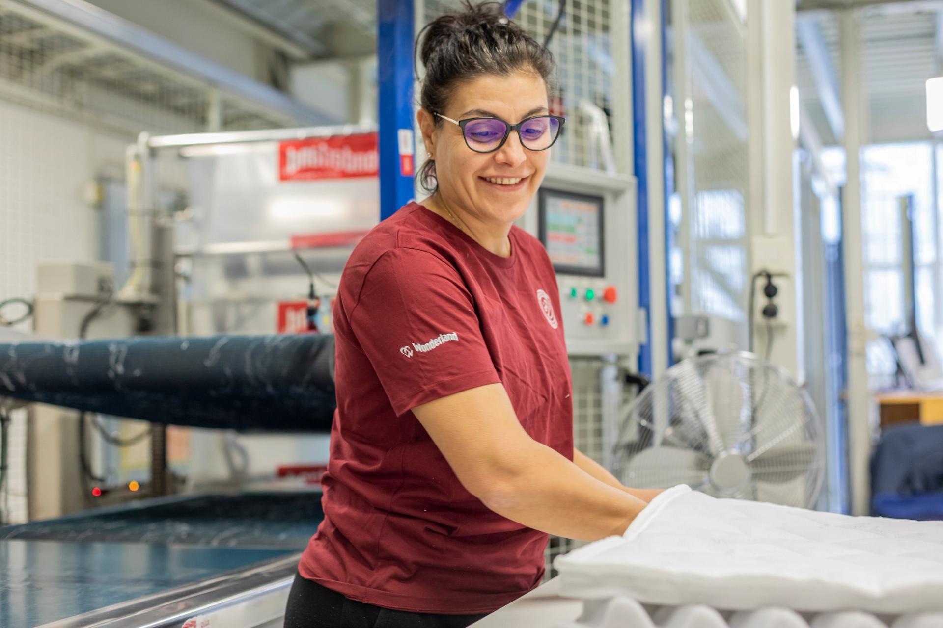 A woman working with the fabric for the bed.