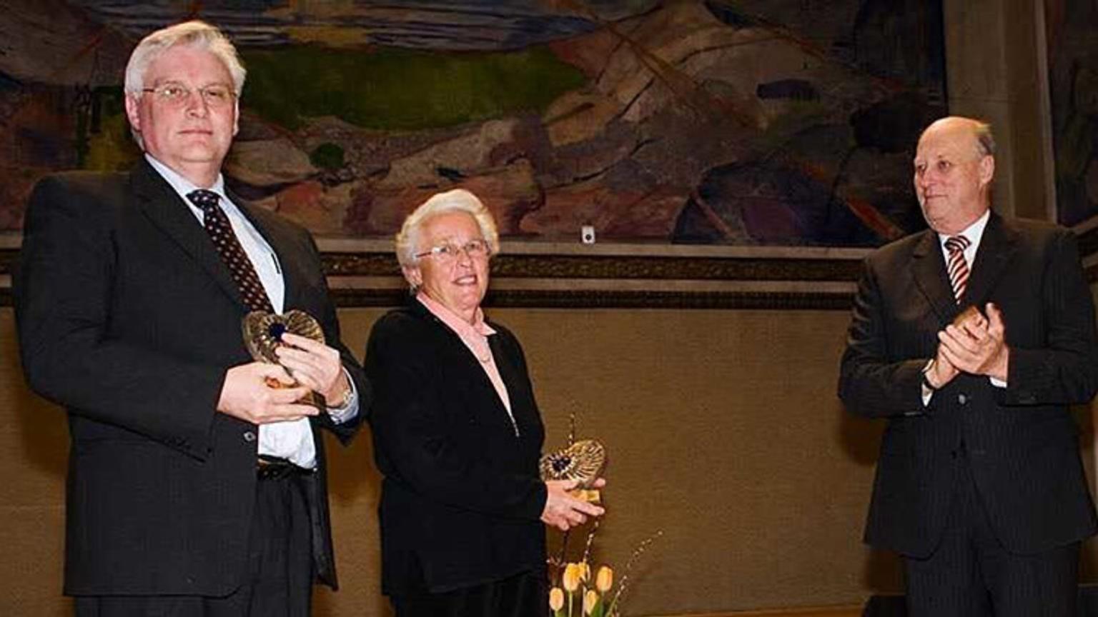 Man and woman receiving awards