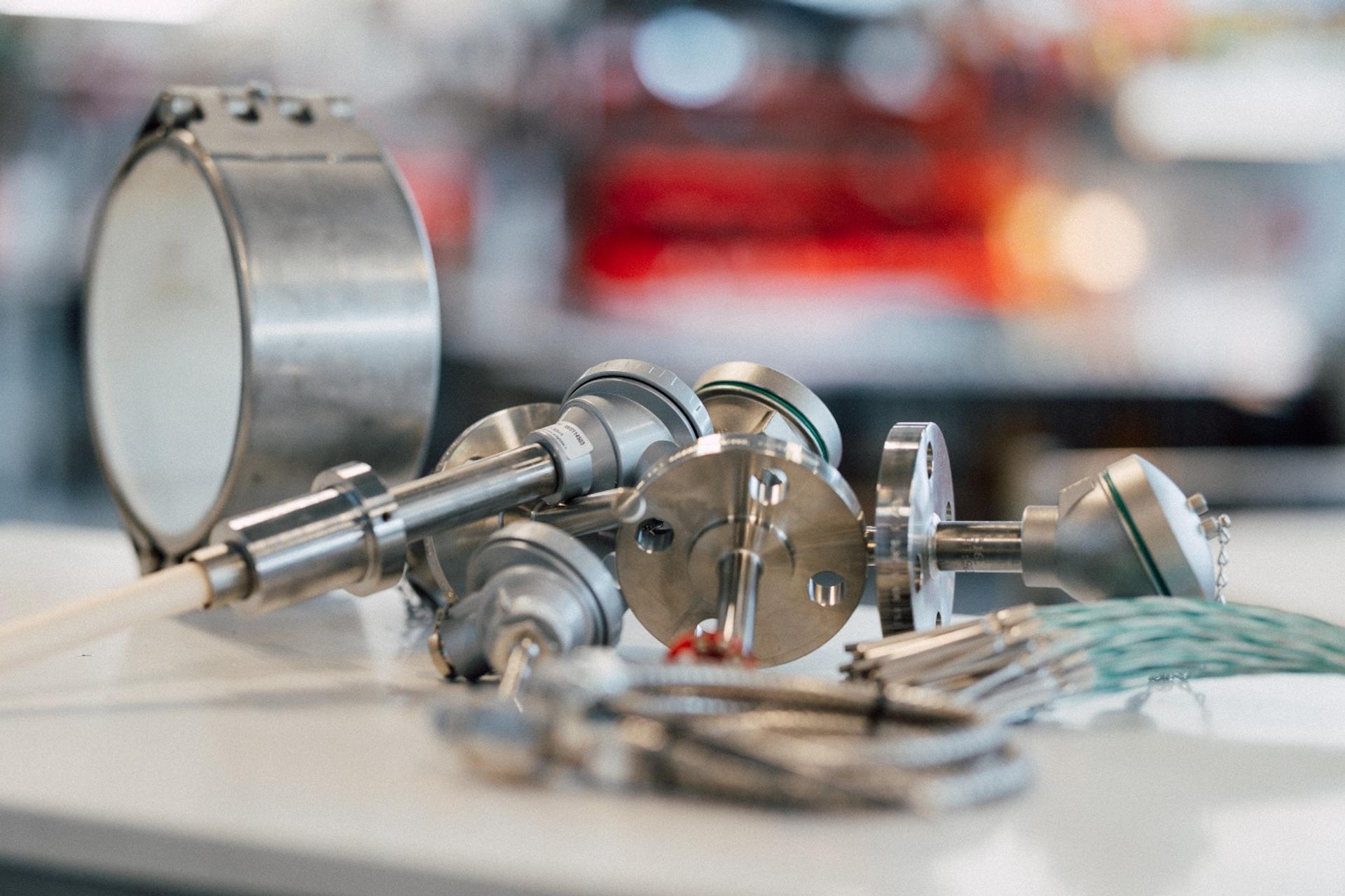 Stainless steel pressure gauges and measurement instruments on a workbench.