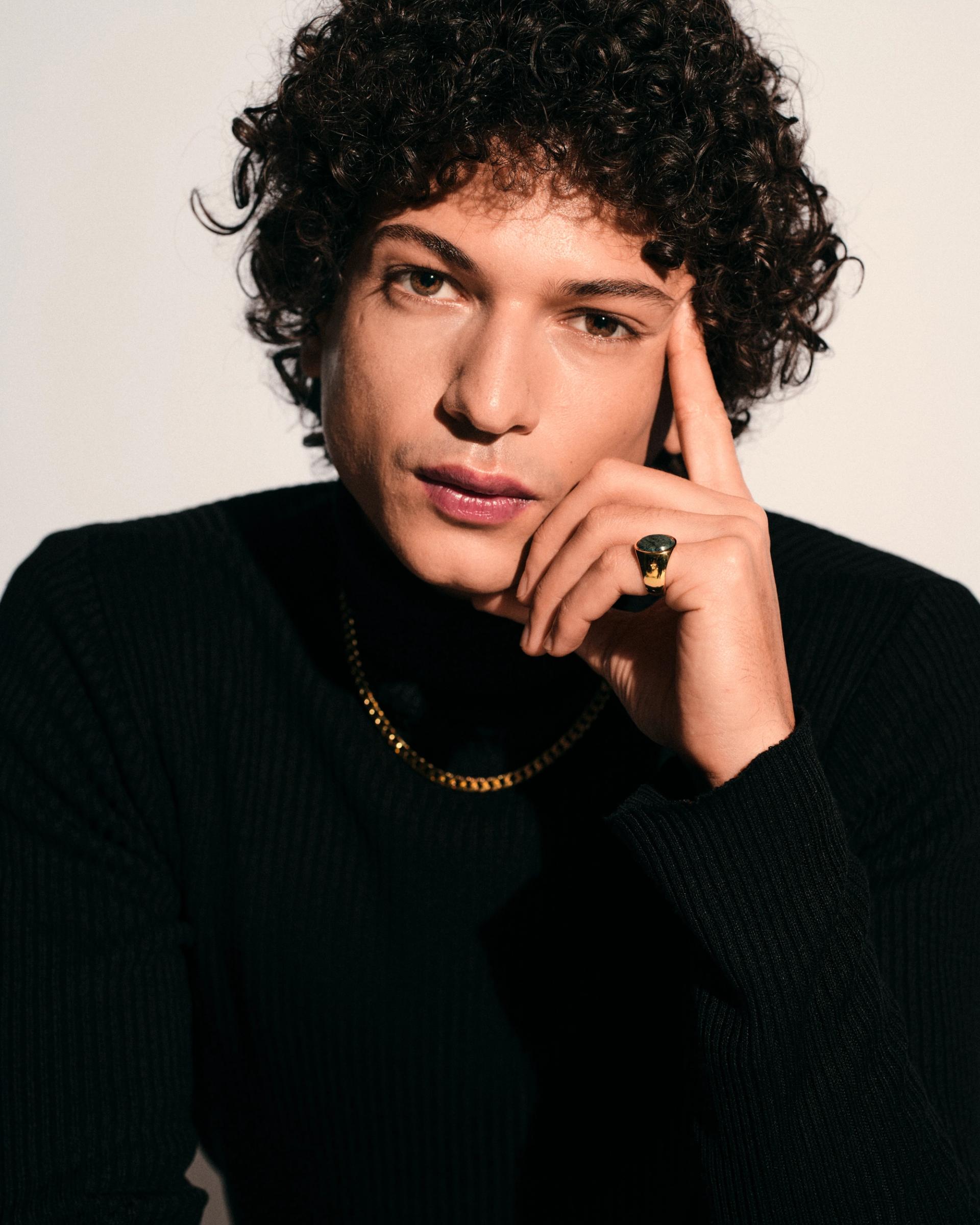 Young man with brown curly hair wearing a gold signet ring with green marble and a gold chain necklaceeen-Marble_