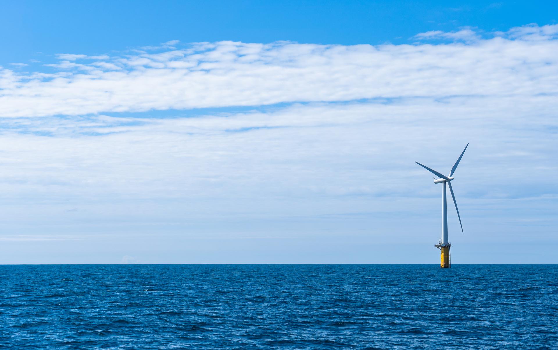 Wind turbine at sea, blue skies