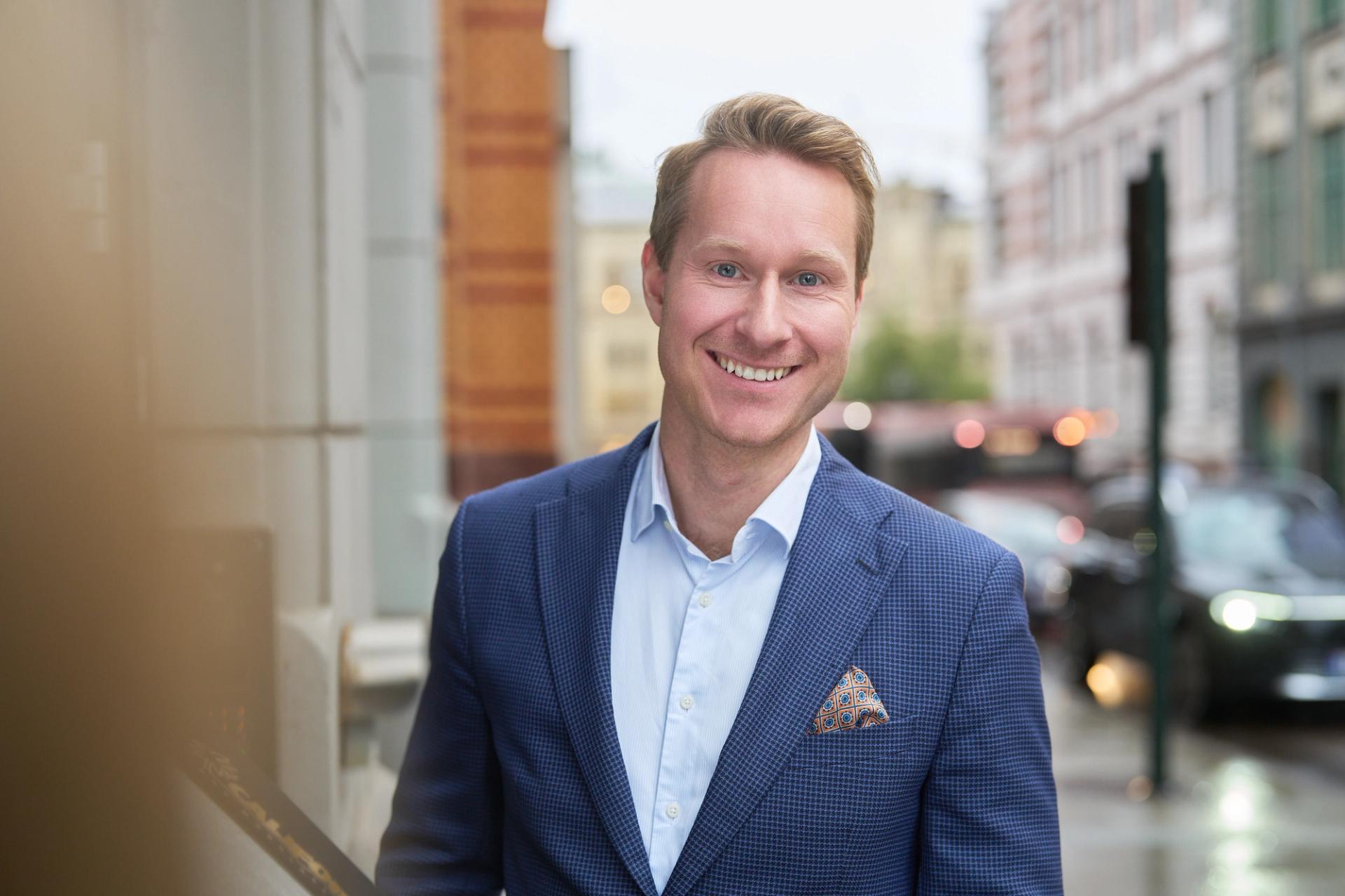 Man in a suite smiling to the camera.