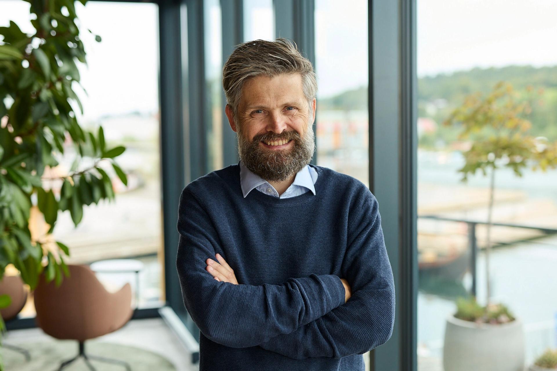 Man with a beard smiling to the camera.