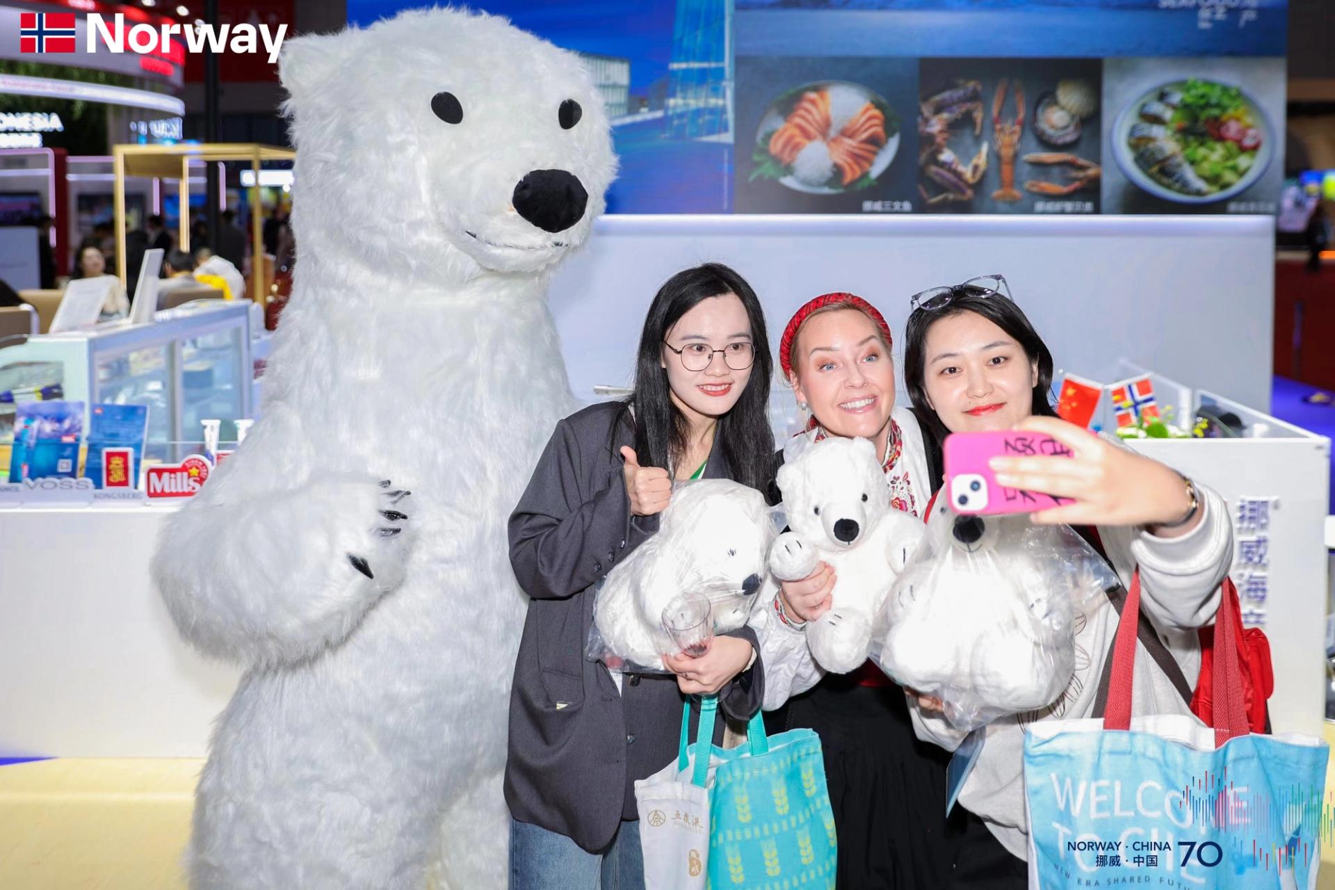 Three women taking a selfie with a teddy polar bear