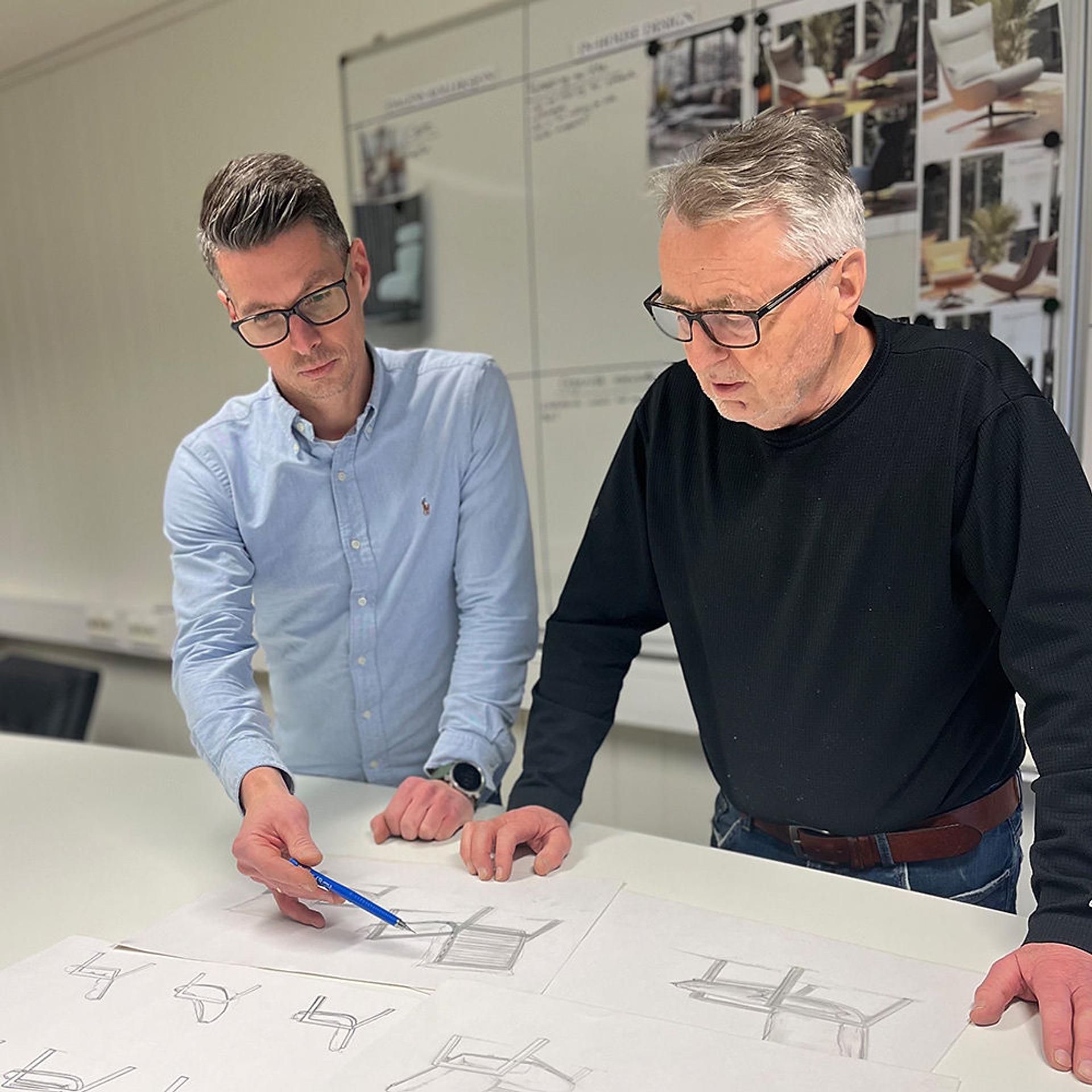 Two men working on designs.