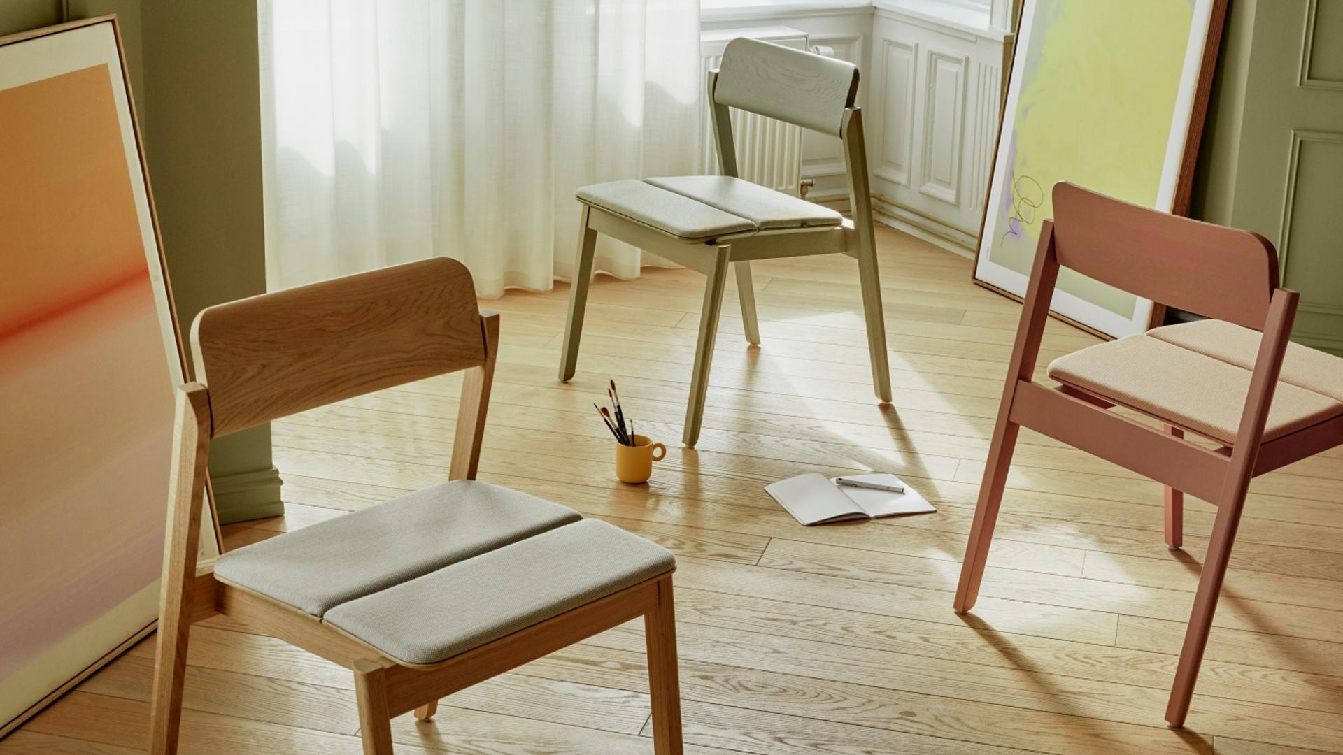 Three wooden chairs, one in green, one in pink and one in whitewashed oak