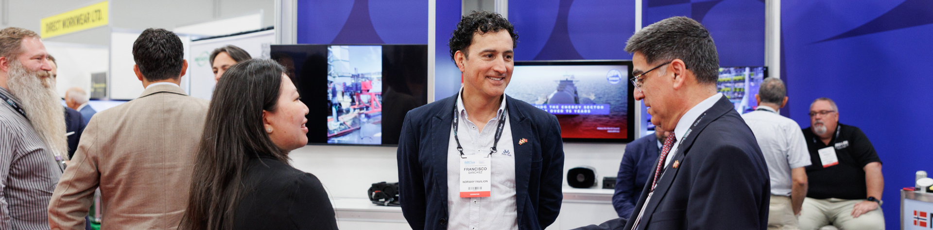 People talking in front of a pavilion at a trade fair