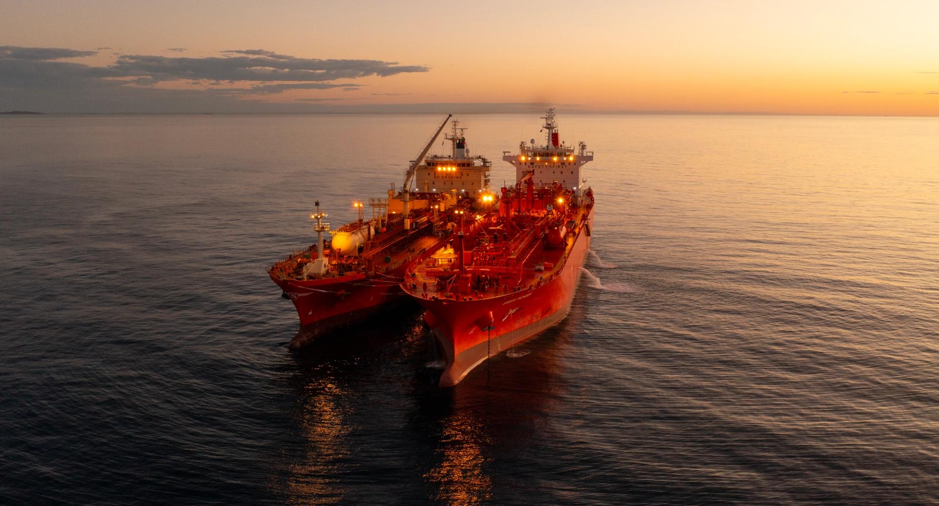 Two red vessels side by side in the sunset